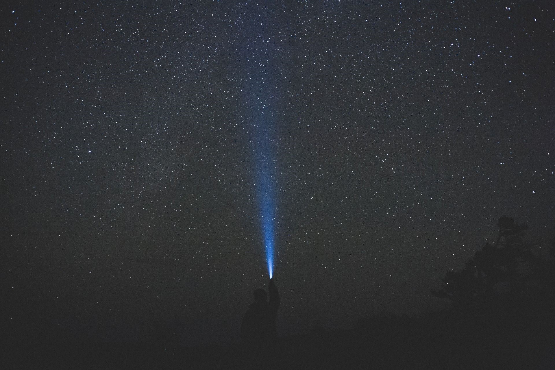 Person shining flashlight at starry night sky HD Wallpaper