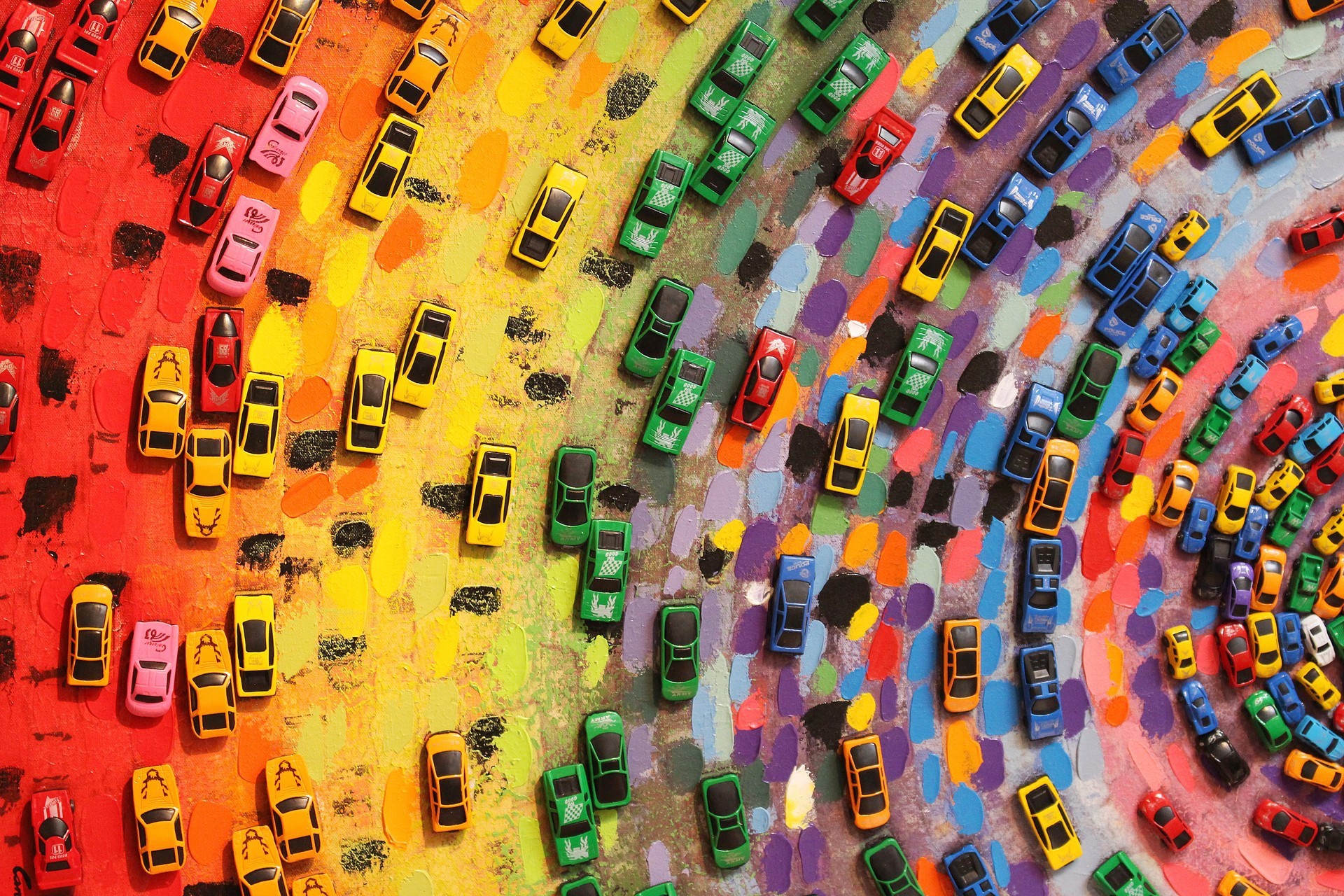 Colorful toy cars arranged on a painted surface HD Wallpaper