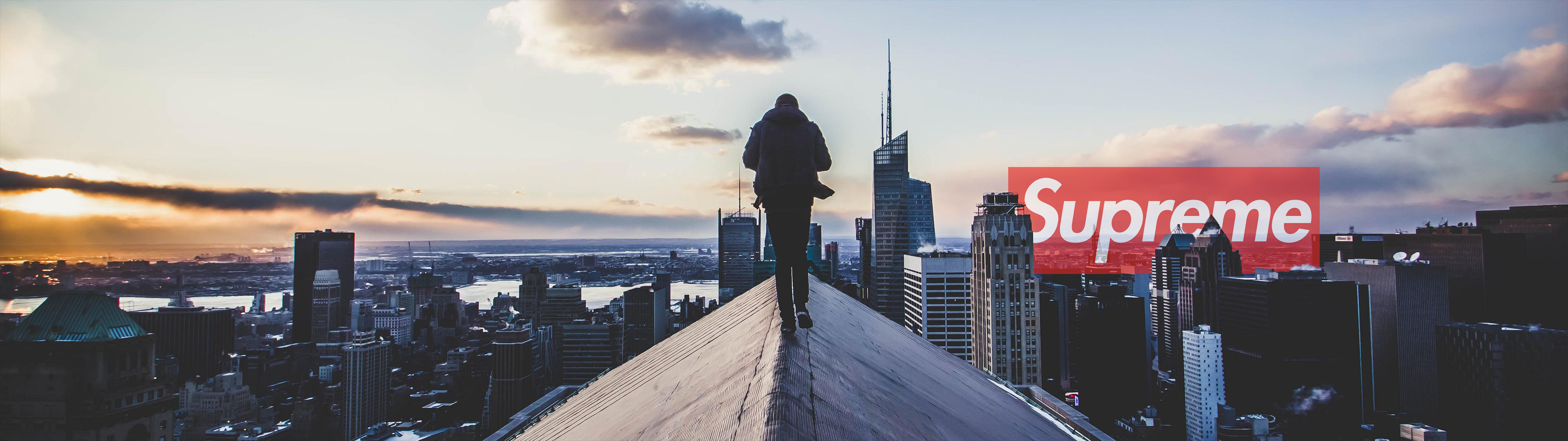 Man on rooftop with Supreme logo over city HD Wallpaper