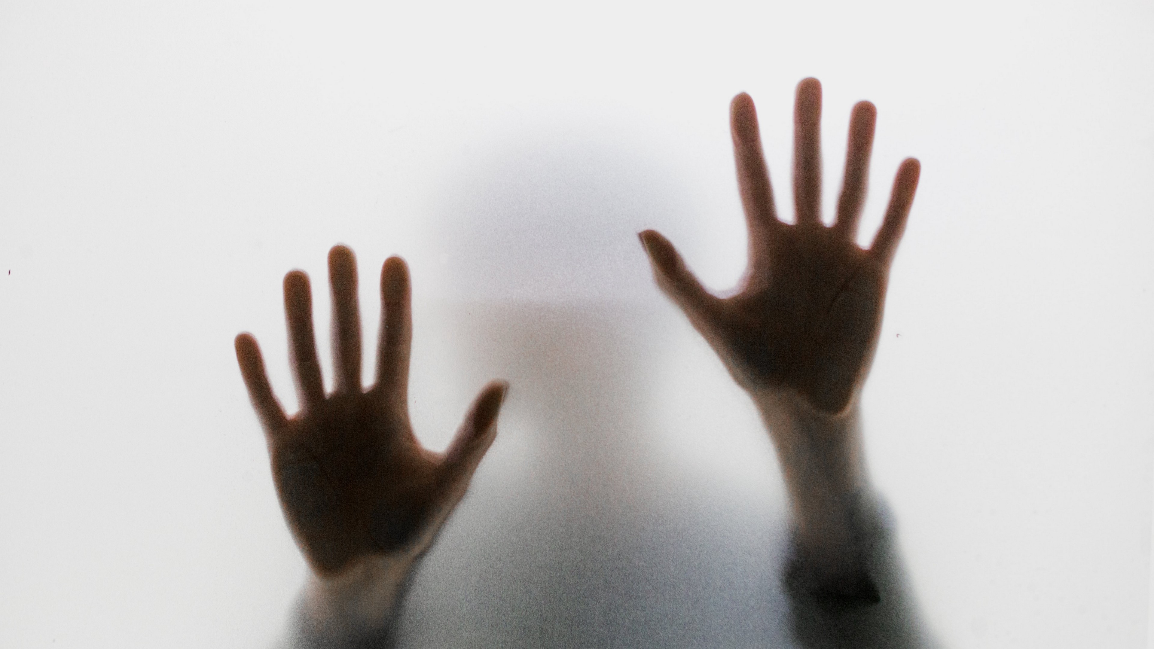 Horror scene with hands pressed against glass HD Wallpaper