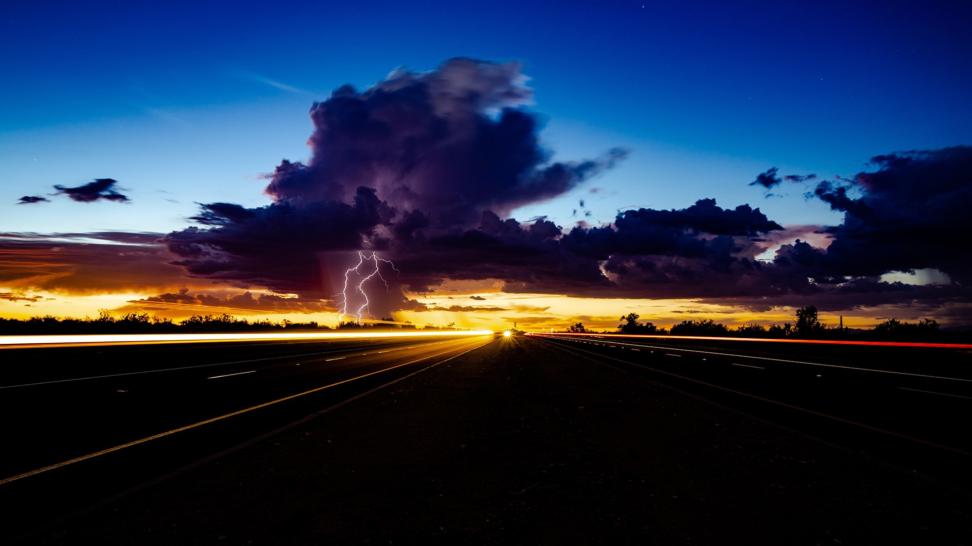 Lightning strikes over a highway at sunset HD Wallpaper