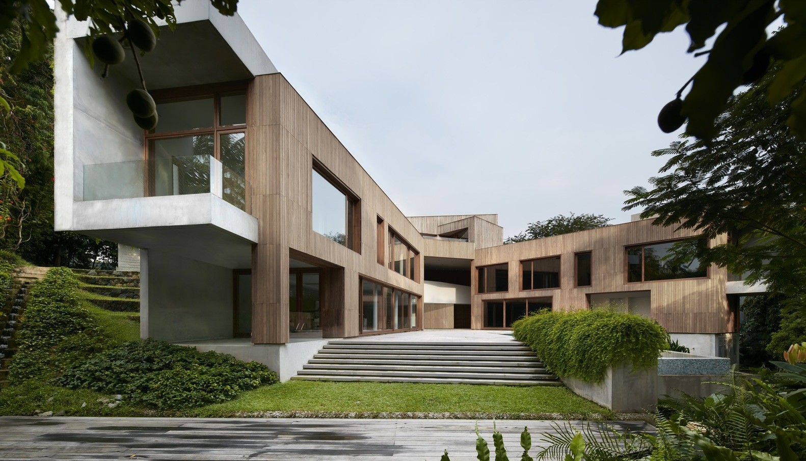 Modern wooden house with concrete elements and greenery HD Wallpaper