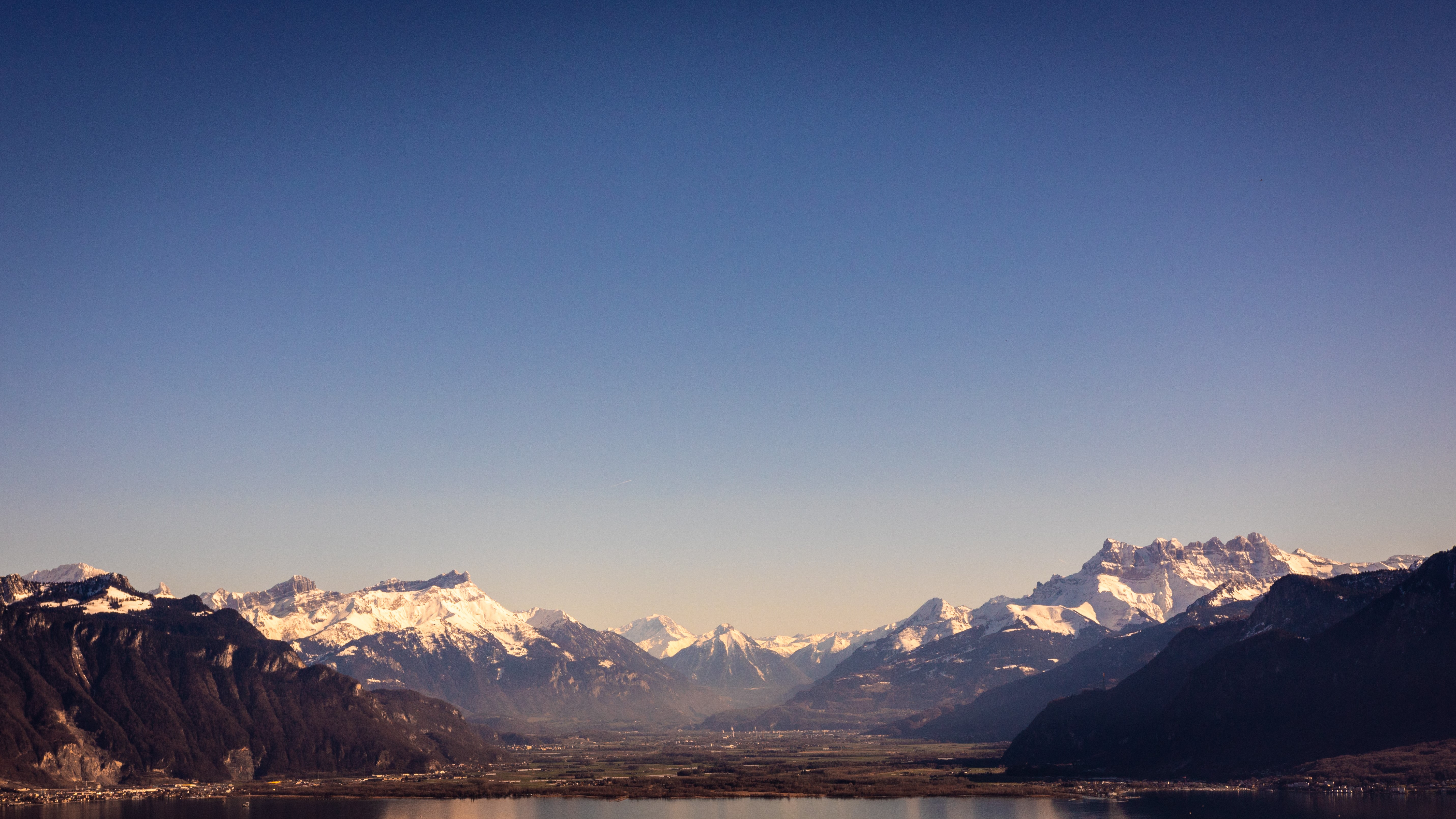 Snow-capped Alps mountains over a lake in Switzerland HD Wallpaper