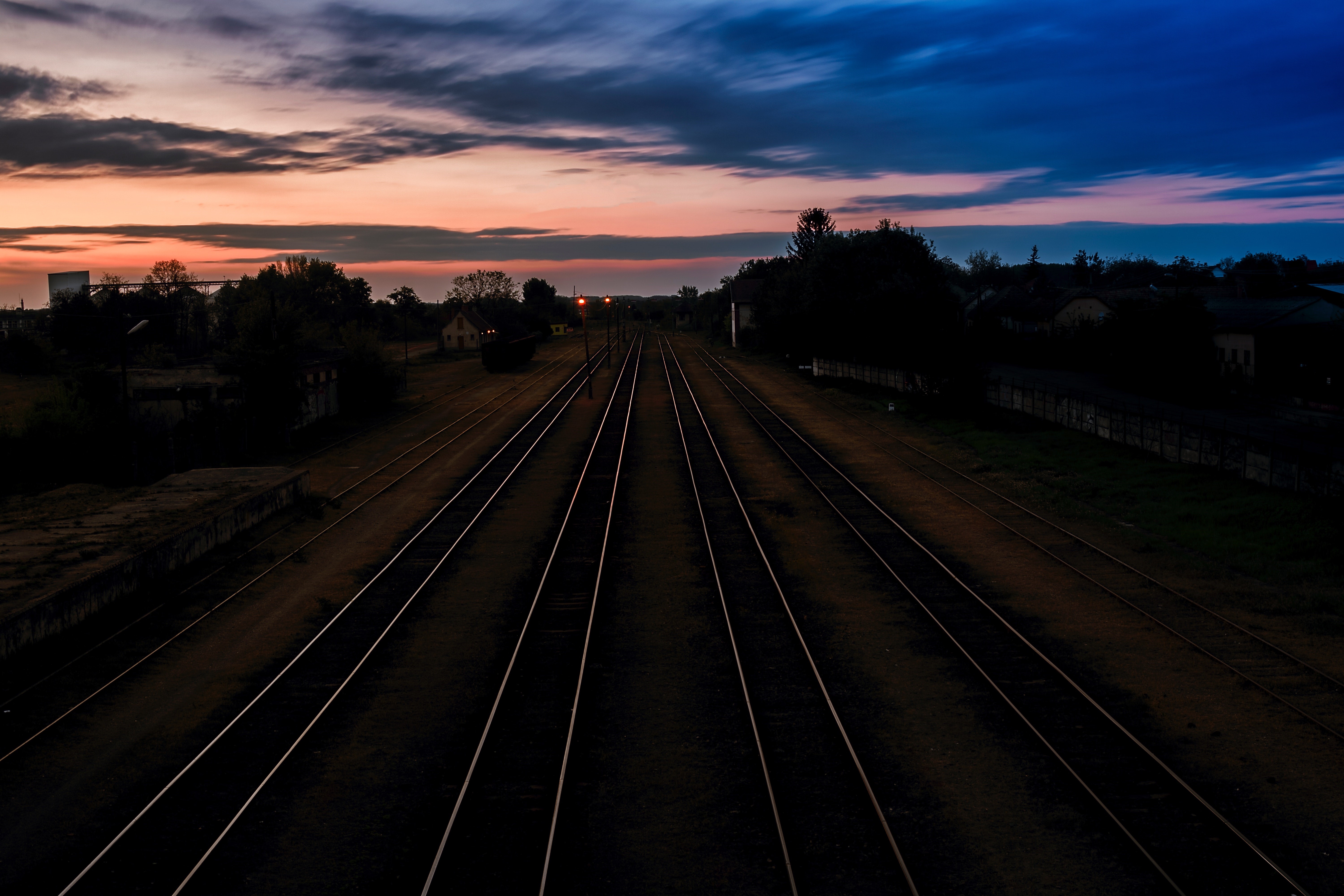 Railway tracks at sunset with dark clouds HD Wallpaper