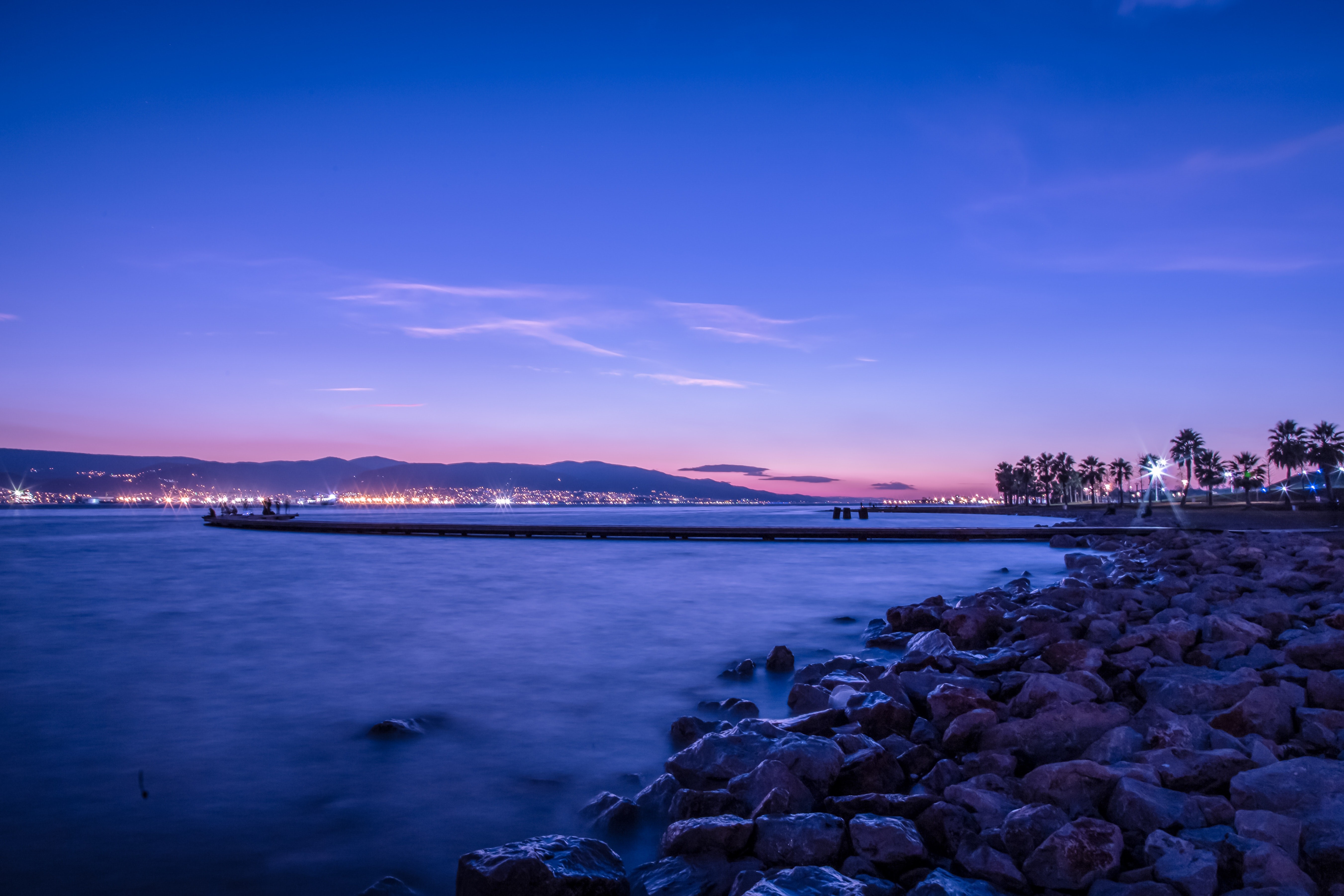 4K blue sea and rocky shore at dusk HD Wallpaper