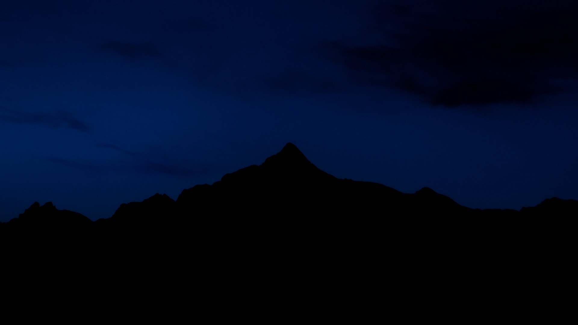 Silhouette of mountains against a dark blue night sky HD Wallpaper