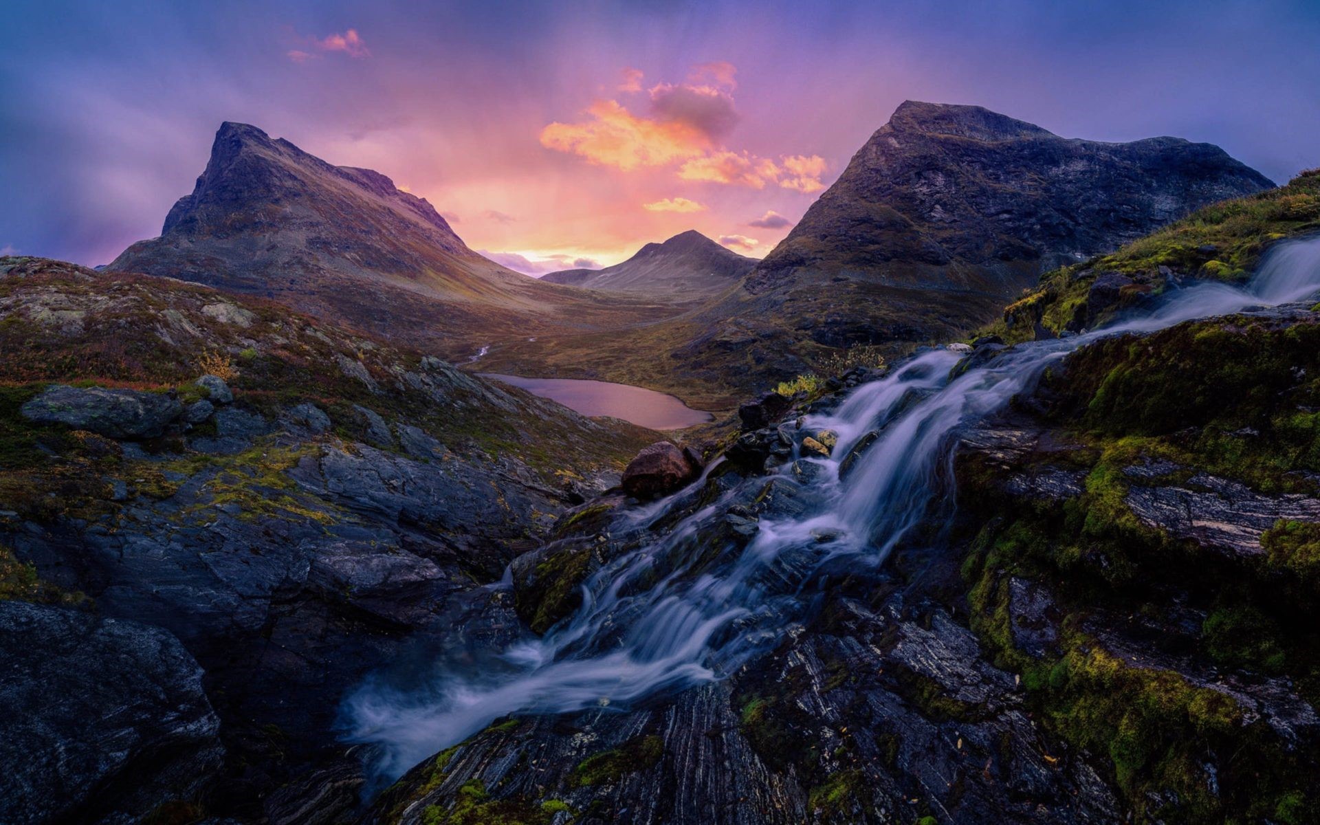 Waterfall flowing over rocks in mountains at sunset HD Wallpaper