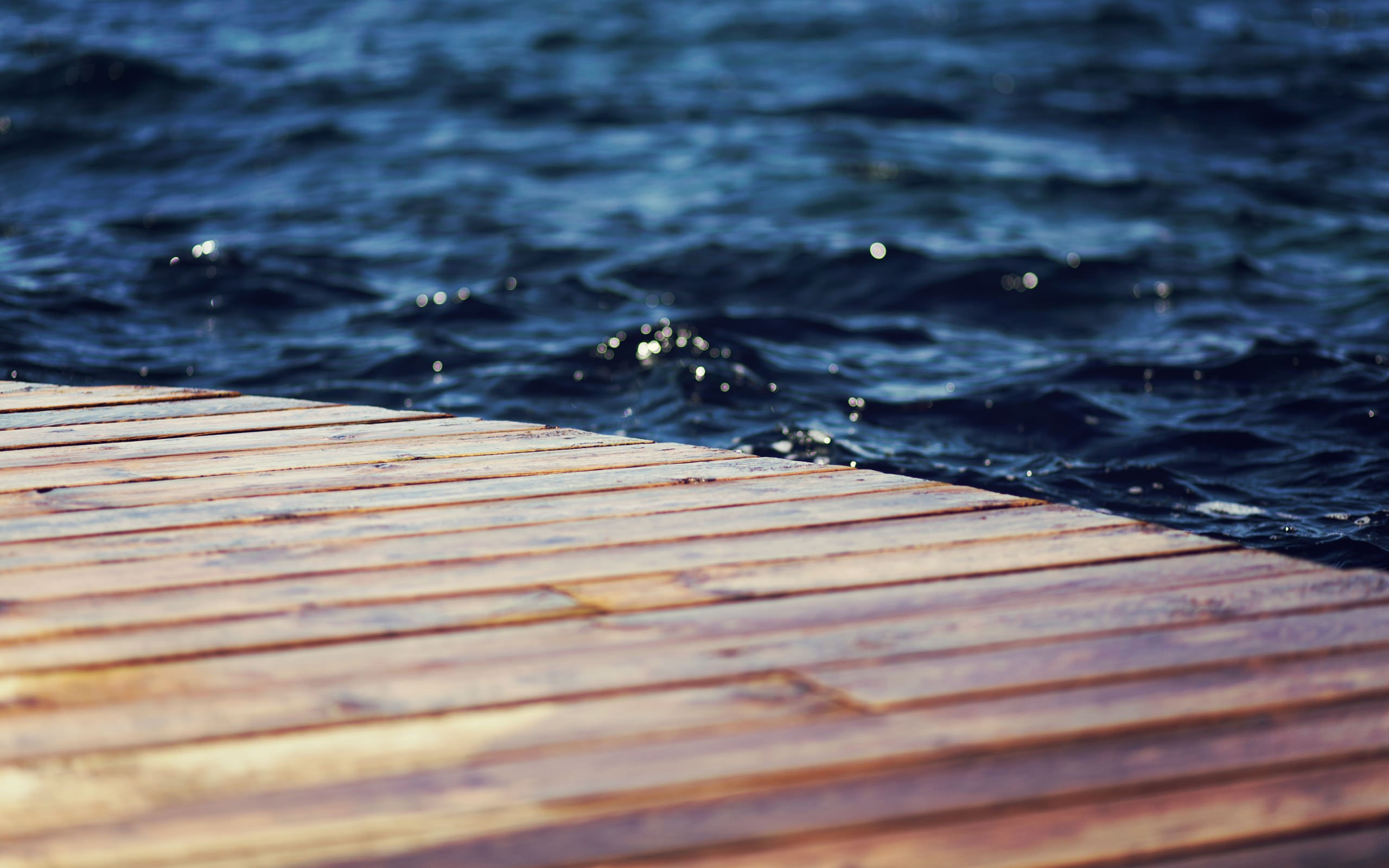 Wooden pier by the dark blue water HD Wallpaper