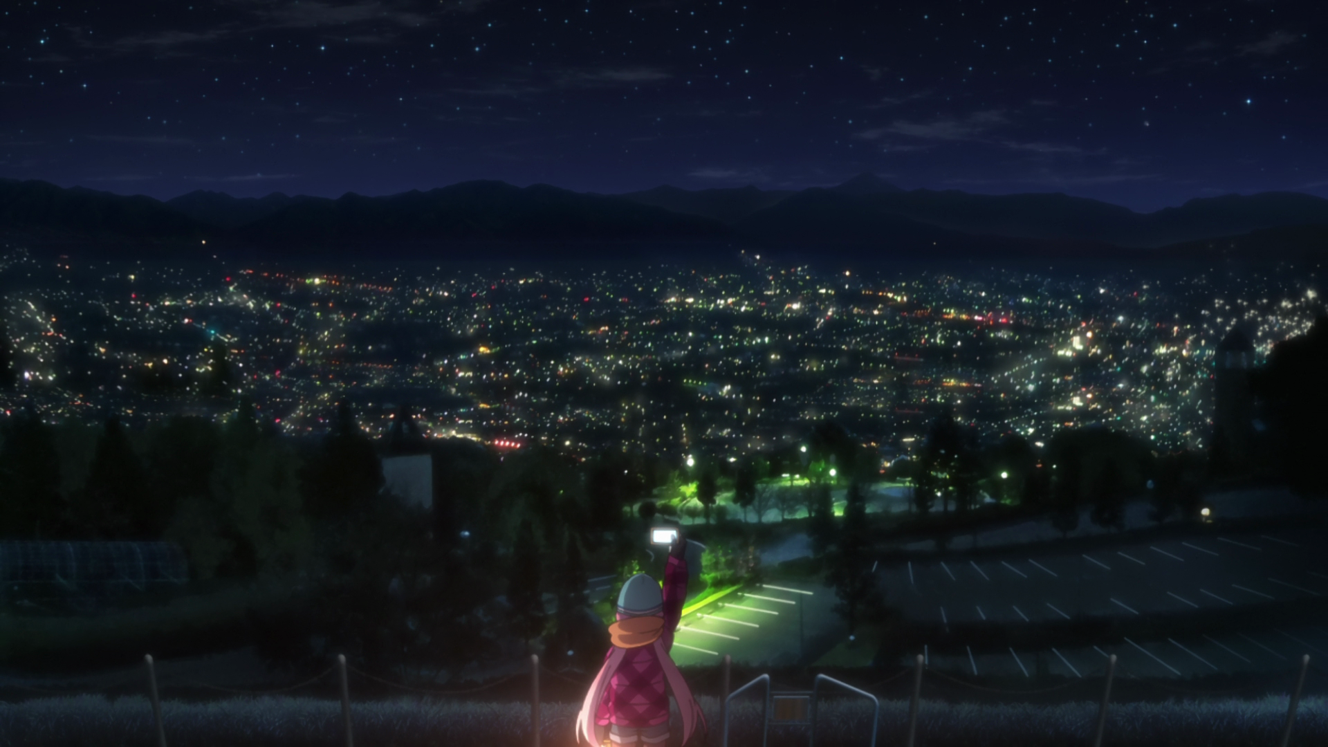 Girl taking a photo of a city at night from a hill HD Wallpaper