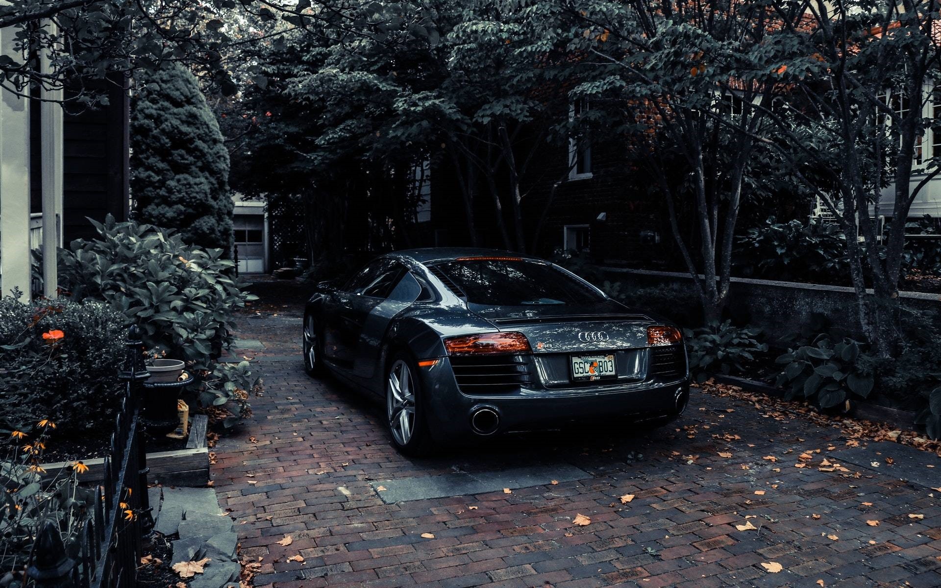 Dark Audi R8 parked on brick driveway HD Wallpaper