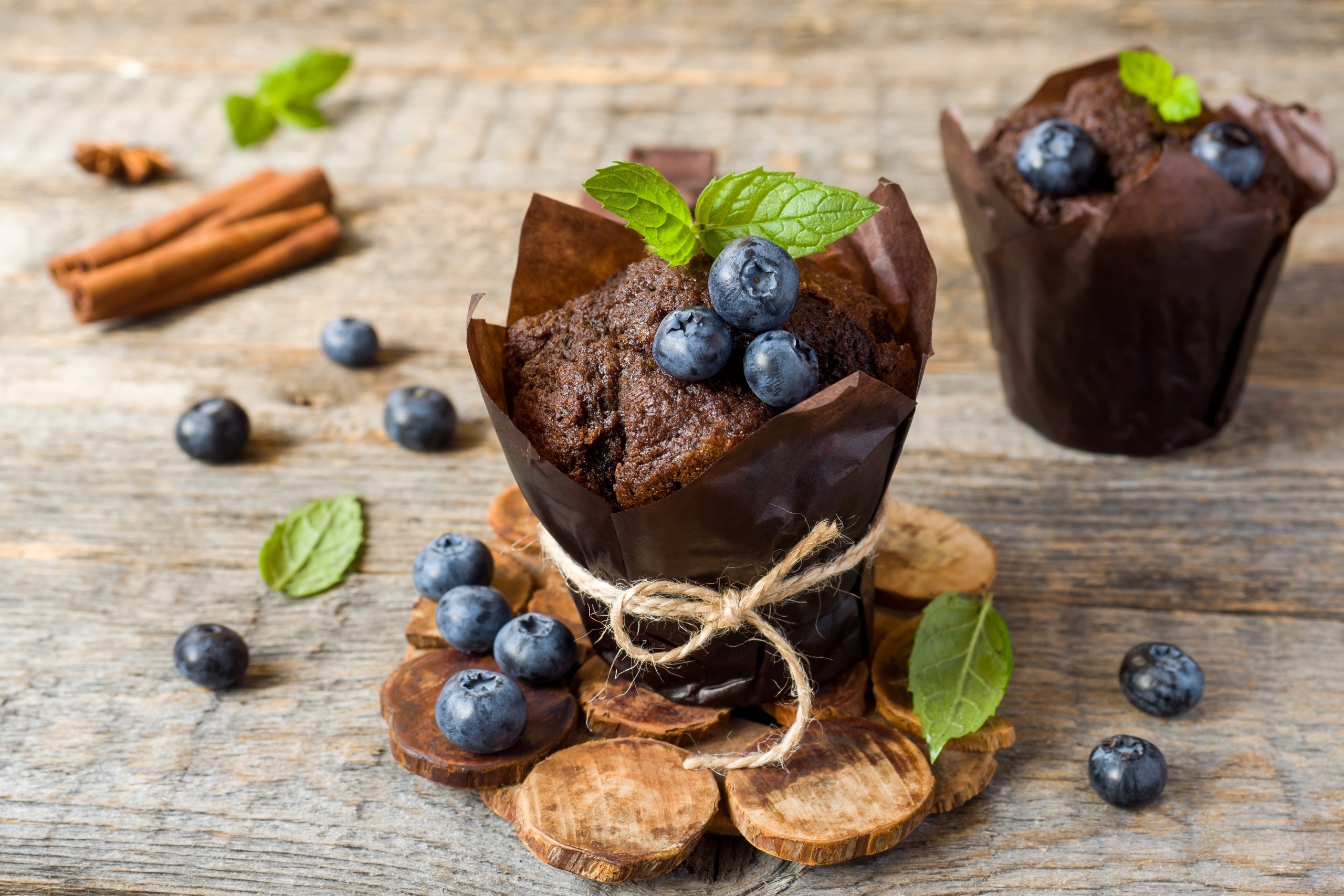 Chocolate muffins with blueberries and cinnamon on a wooden surface HD Wallpaper