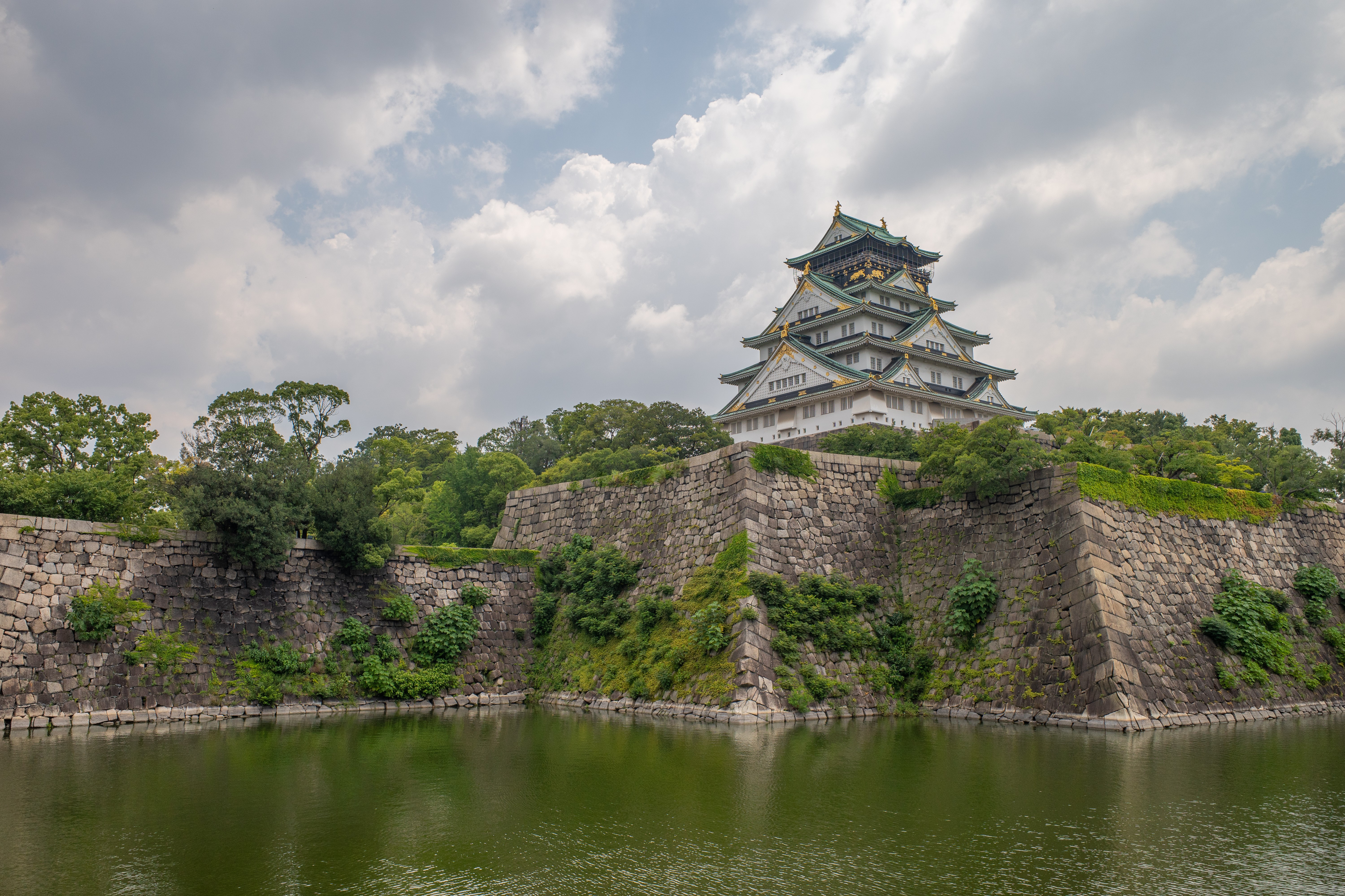 Osaka Castle surrounded by stone walls and moat in Japan HD Wallpaper