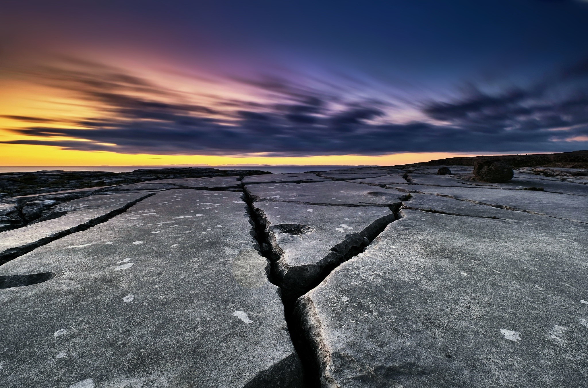 Cracked rock formations on a coast at sunset HD Wallpaper