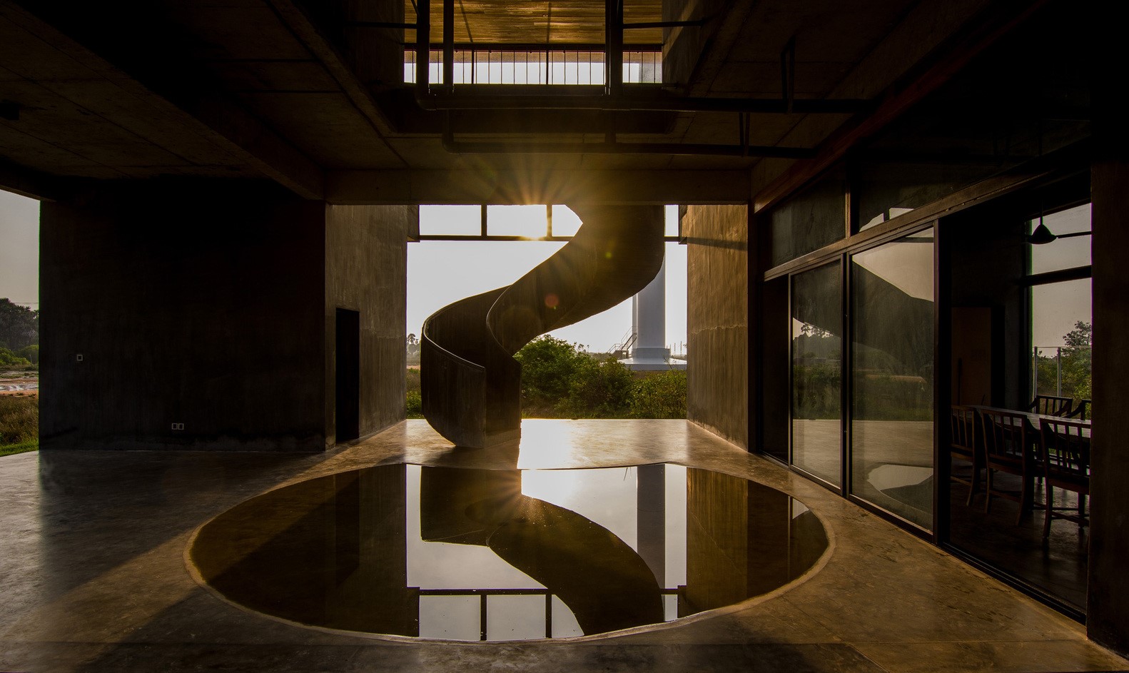 Spiral staircase reflected in water at sunset HD Wallpaper