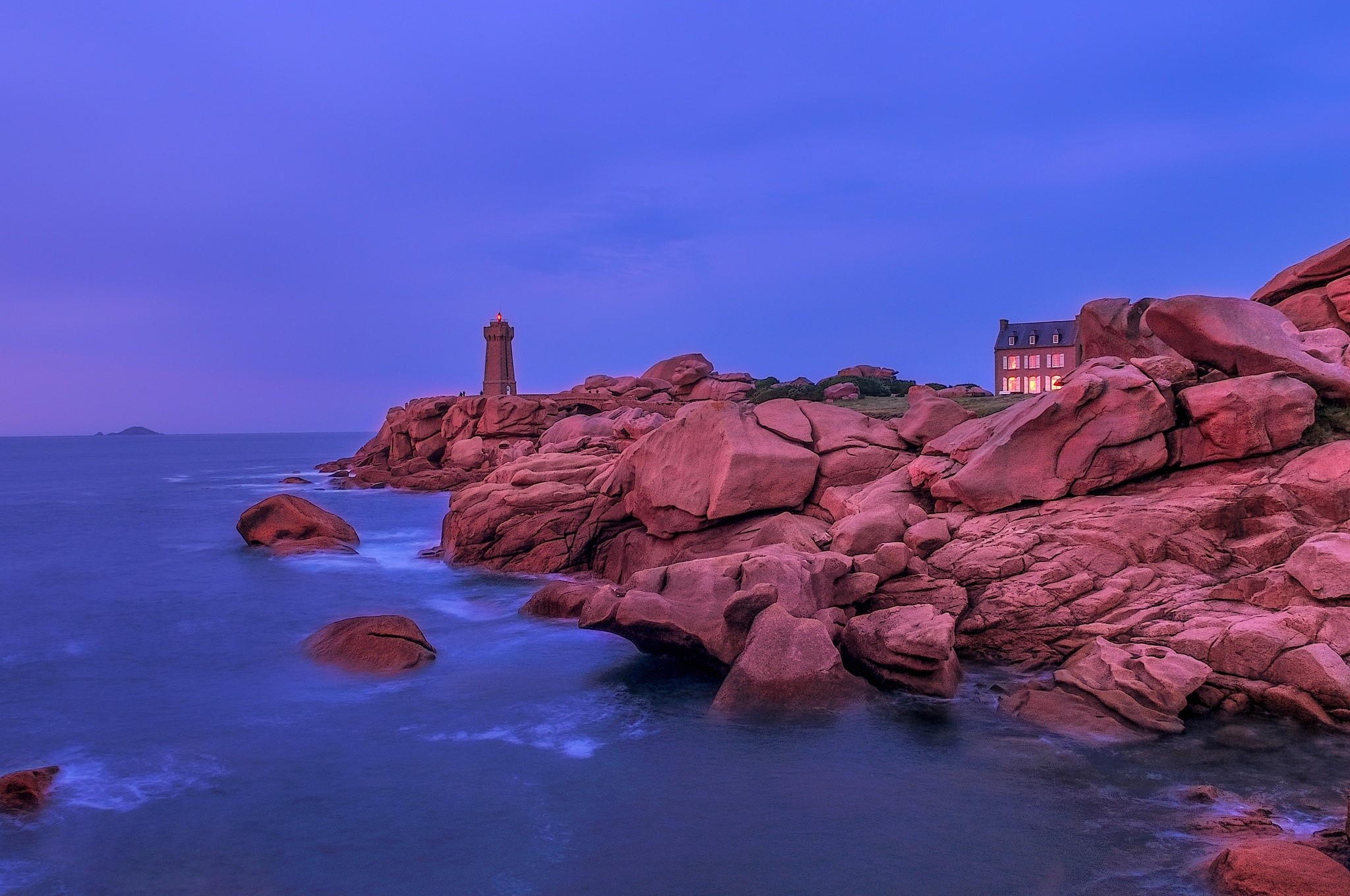 Lighthouse and house on rocky coast at dusk HD Wallpaper