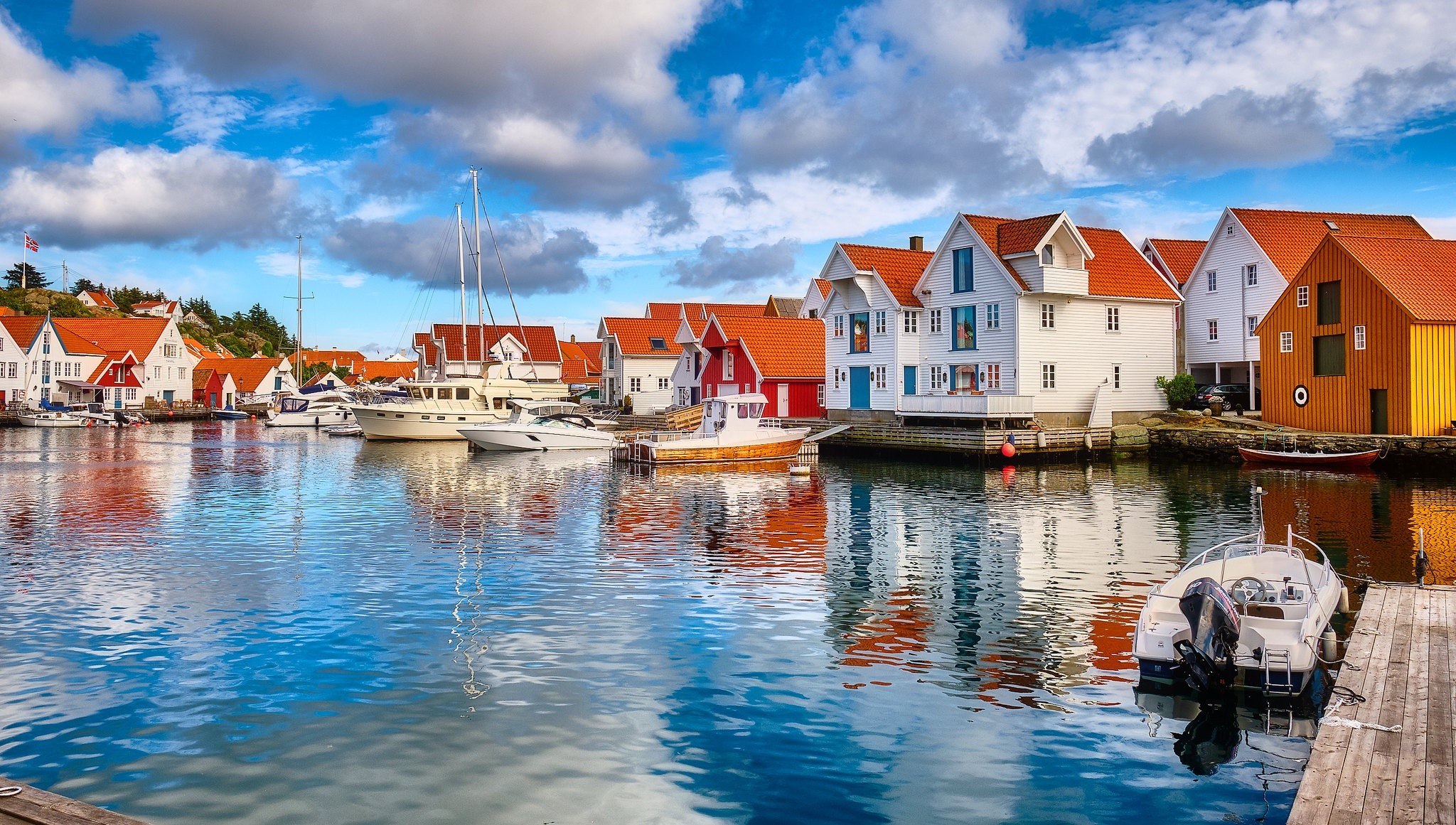 Boats docked in a Norwegian harbor with colorful houses HD Wallpaper