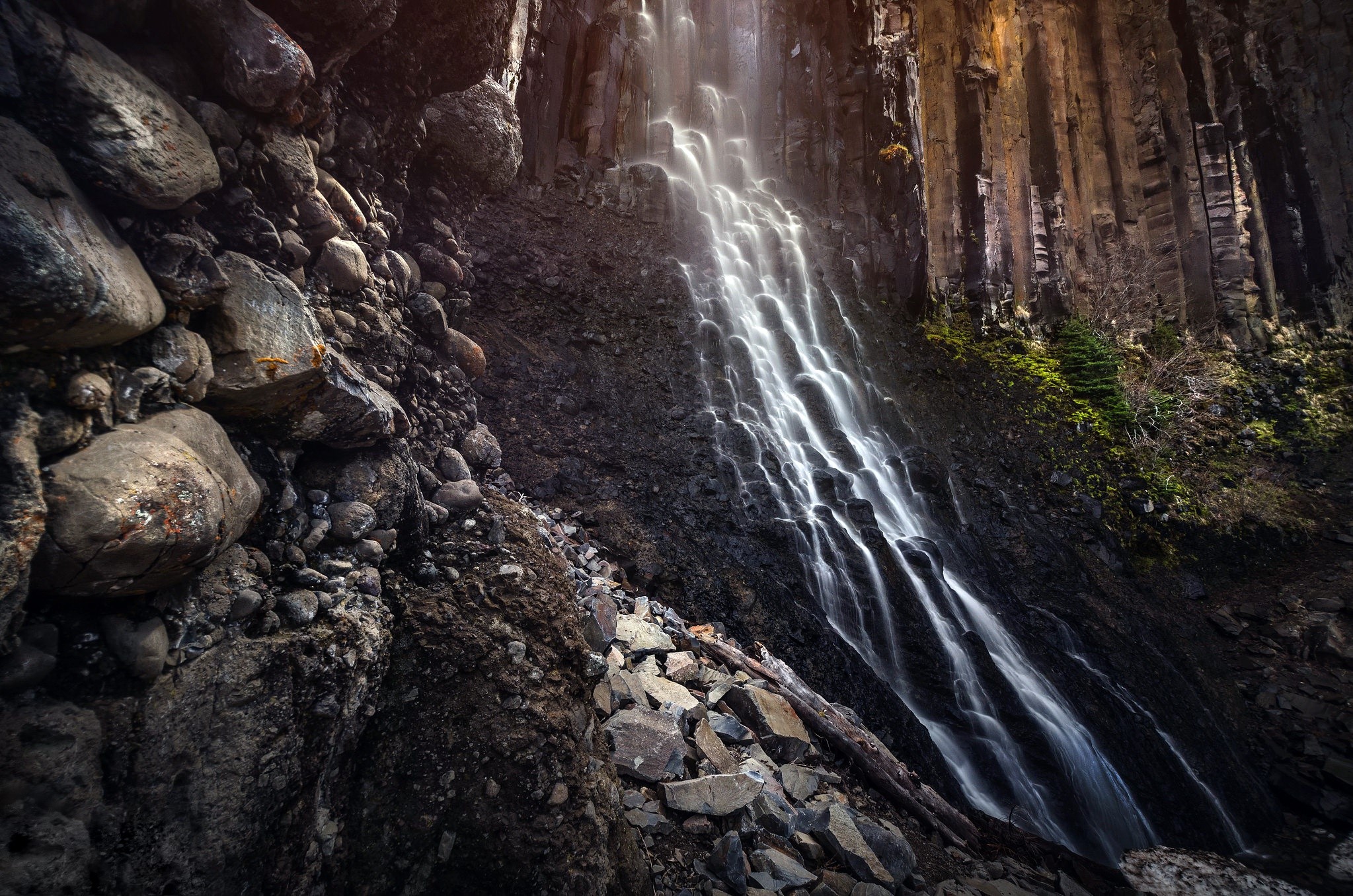 Waterfall cascading over basalt columns and rocks HD Wallpaper