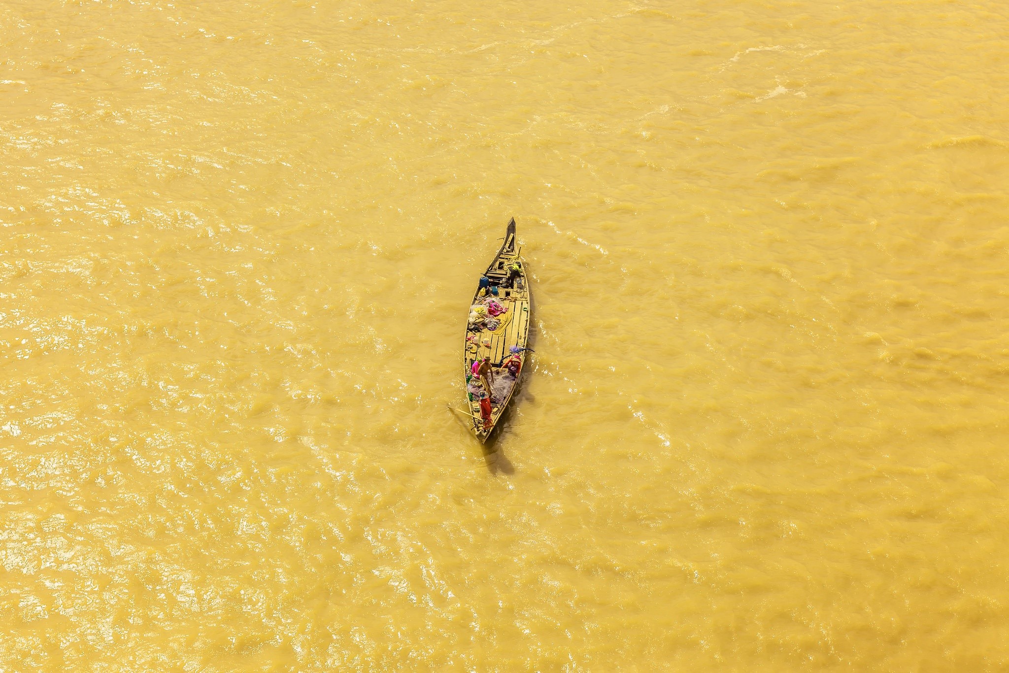 Boat laden with goods on yellow water HD Wallpaper