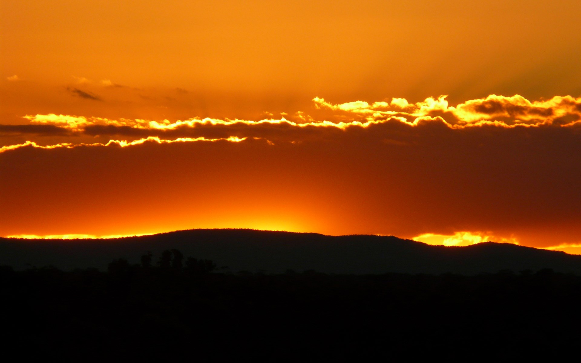Sunset over silhouetted hills and clouds HD Wallpaper