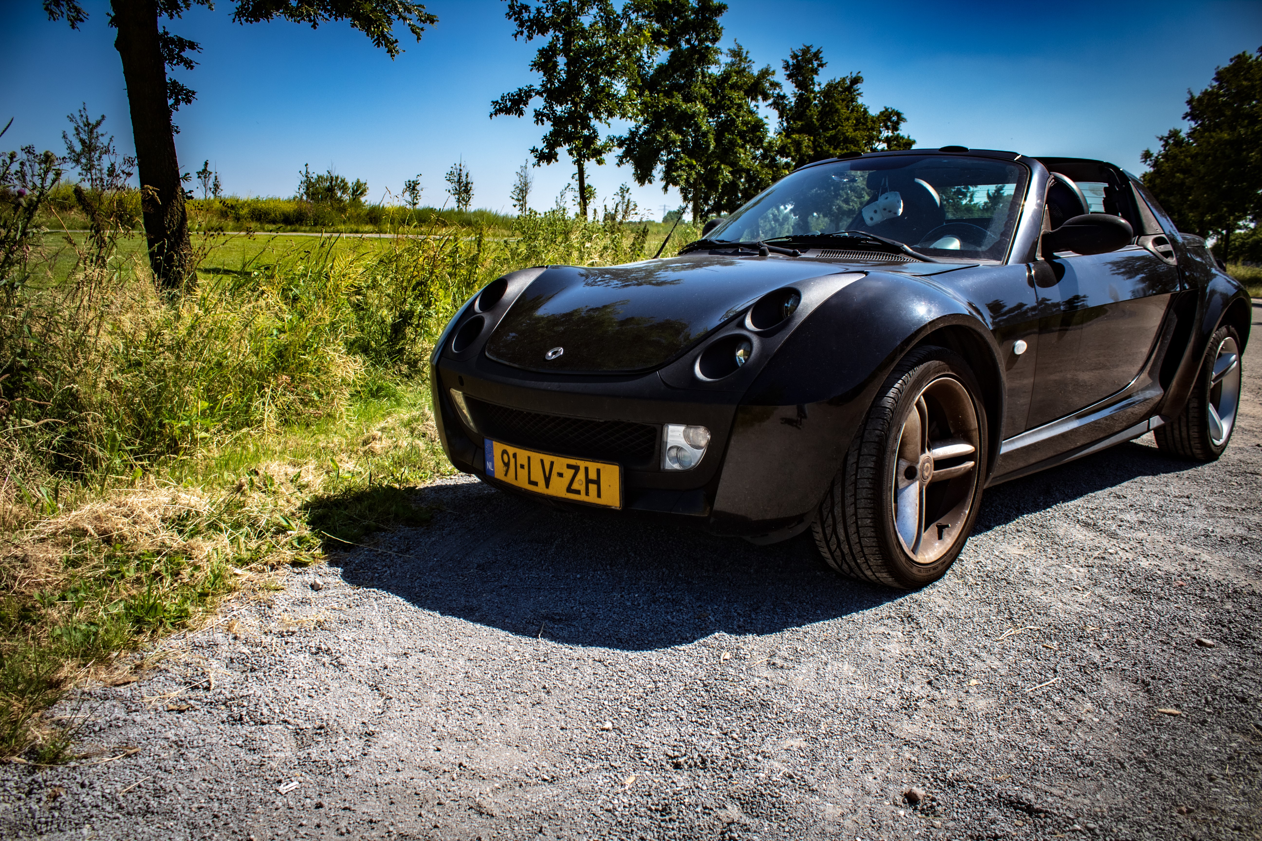 Smart Roadster on a gravel road HD Wallpaper