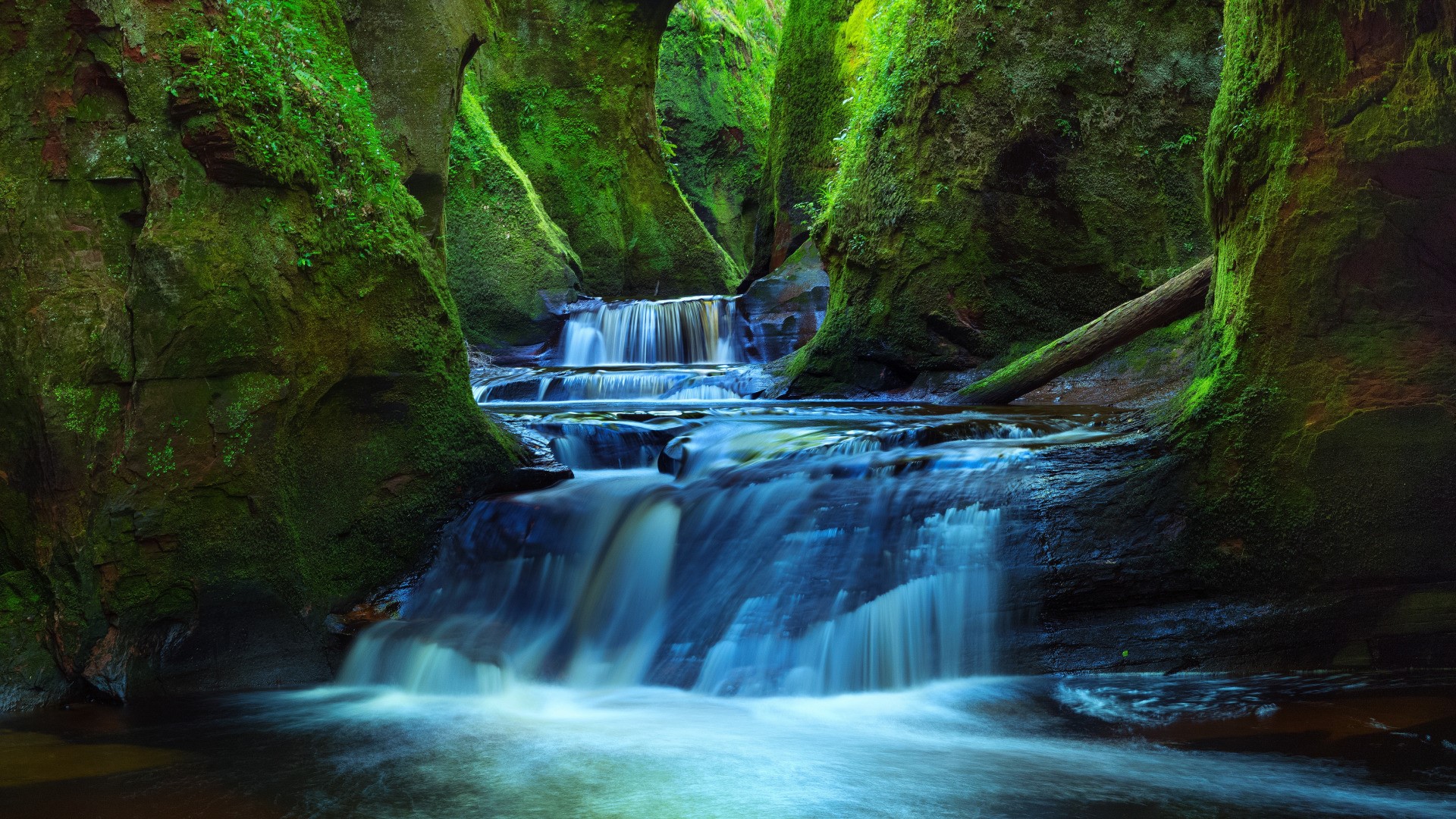 Moss-covered gorge with cascading waterfalls in Scotland HD Wallpaper