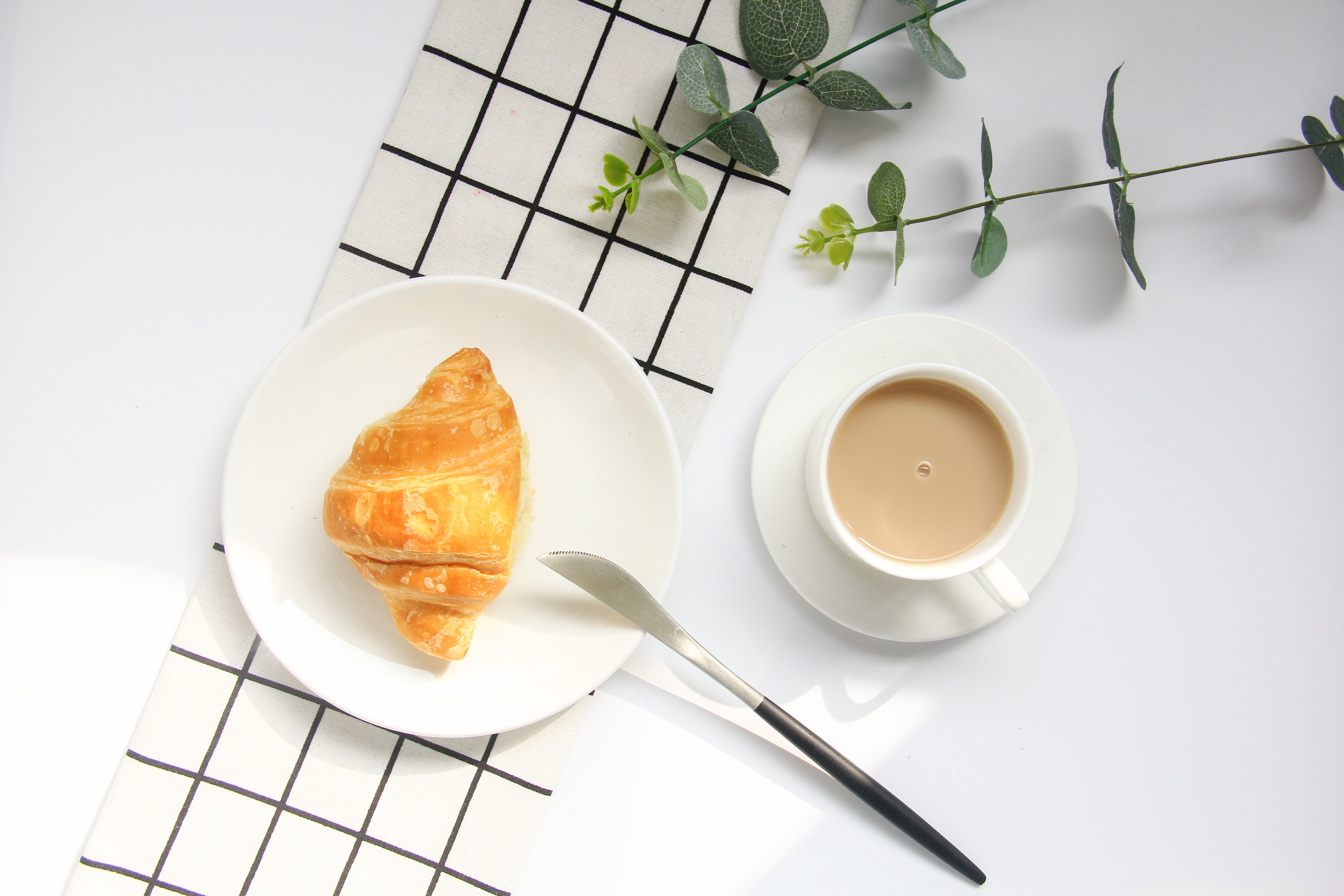Croissant and coffee with eucalyptus leaves HD Wallpaper