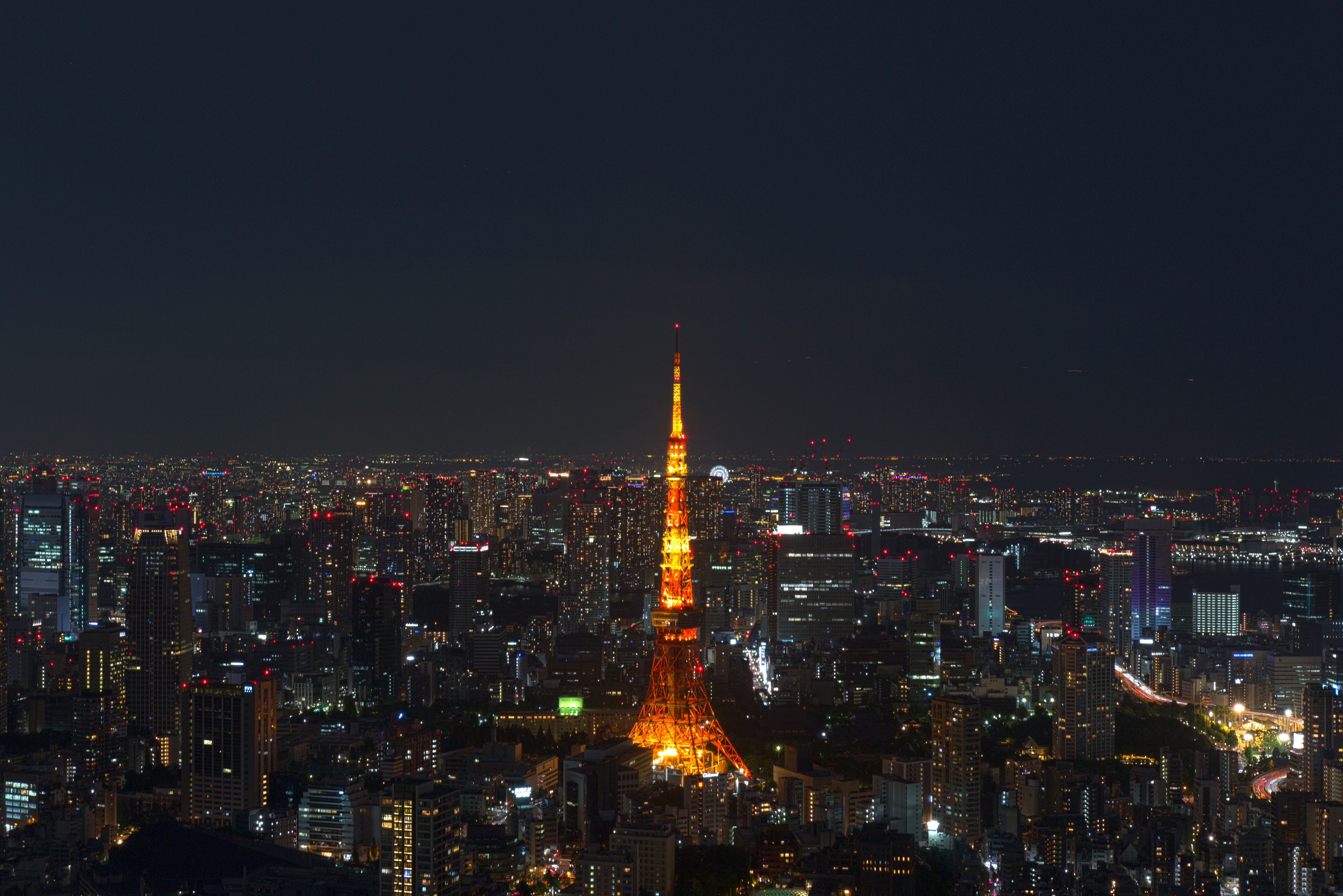 Tokyo Tower illuminated at night over cityscape HD Wallpaper