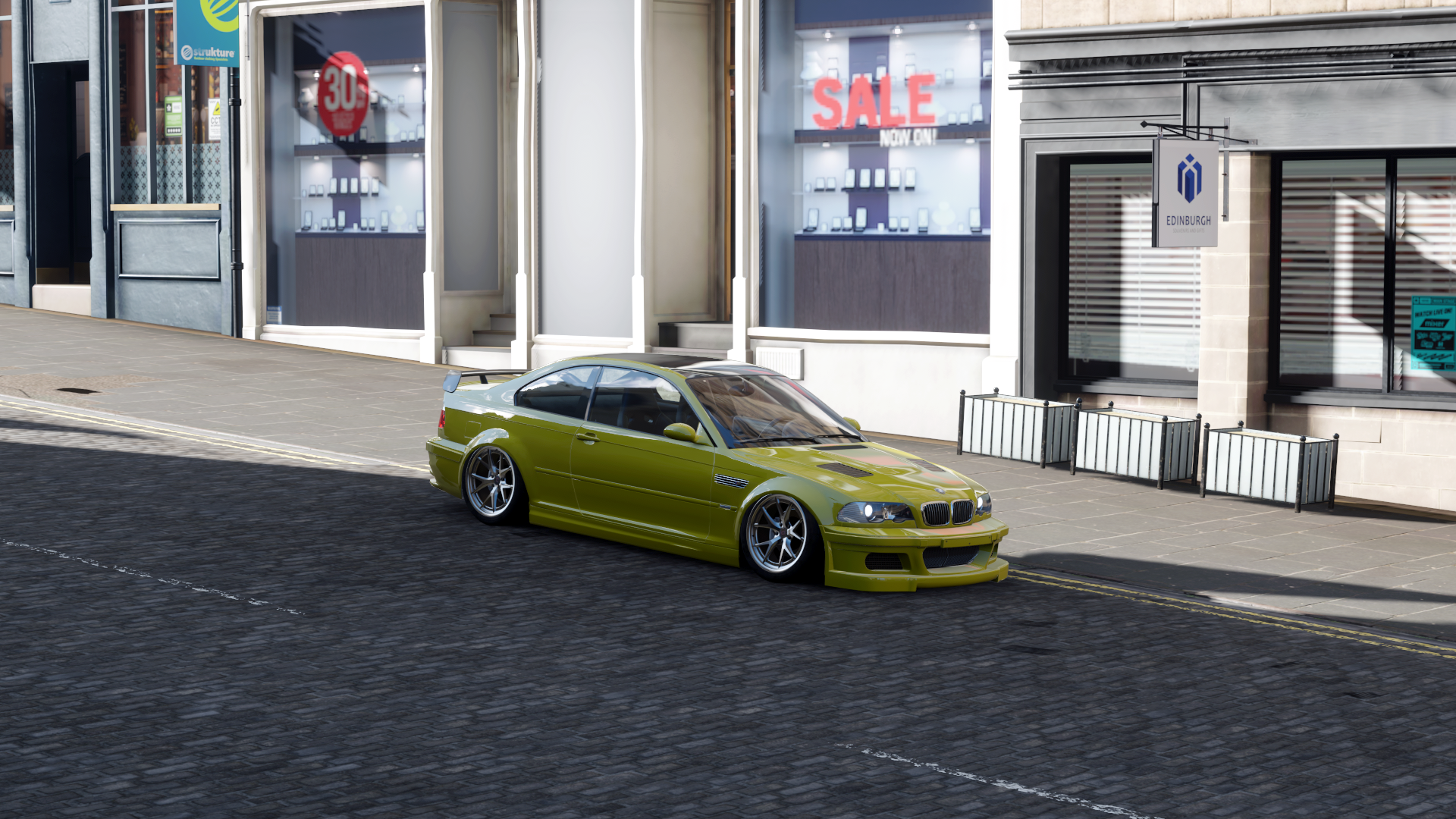 Yellow BMW M3 GTR on a cobblestone street HD Wallpaper