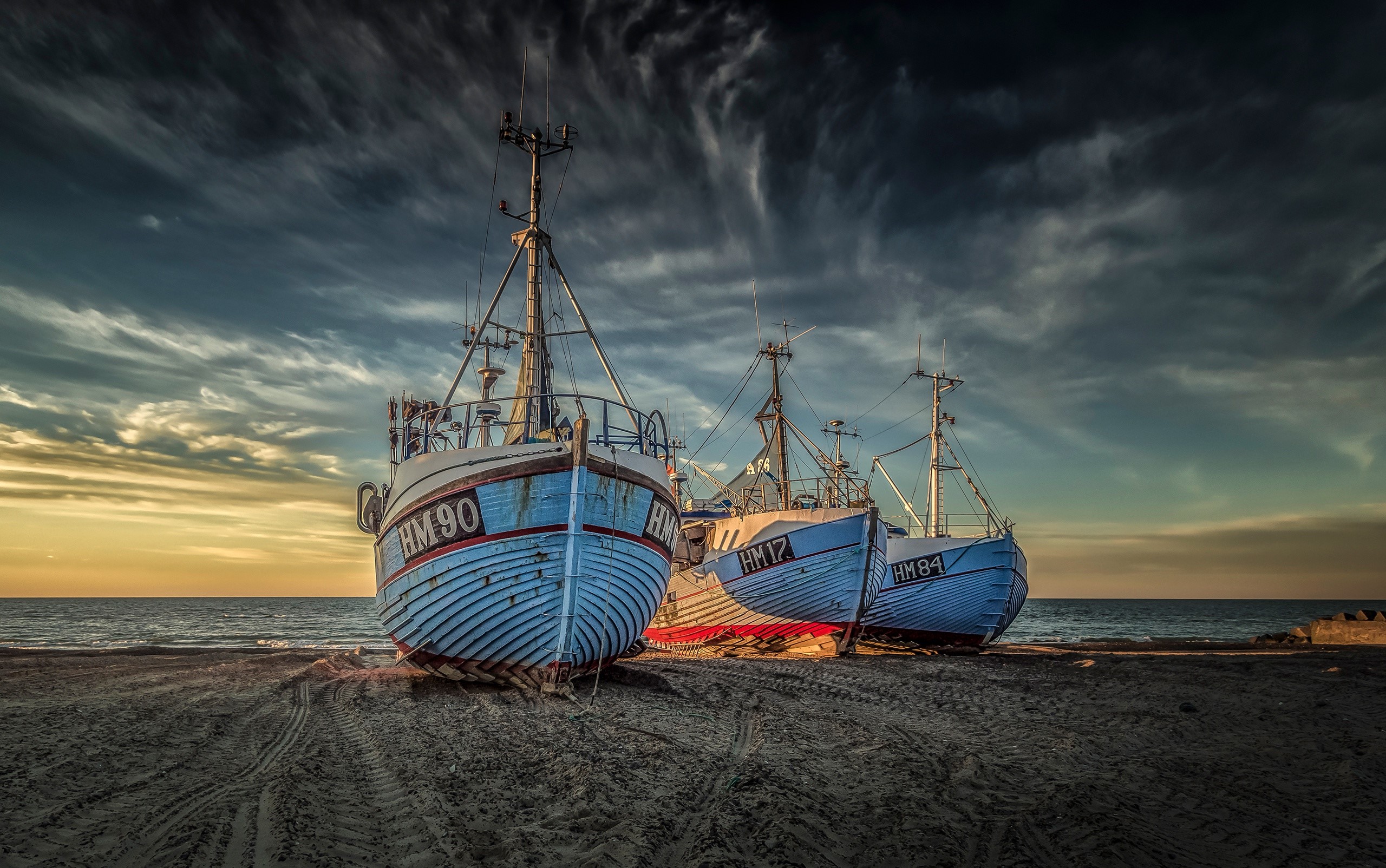 Three fishing boats on a sandy beach at sunset HD Wallpaper