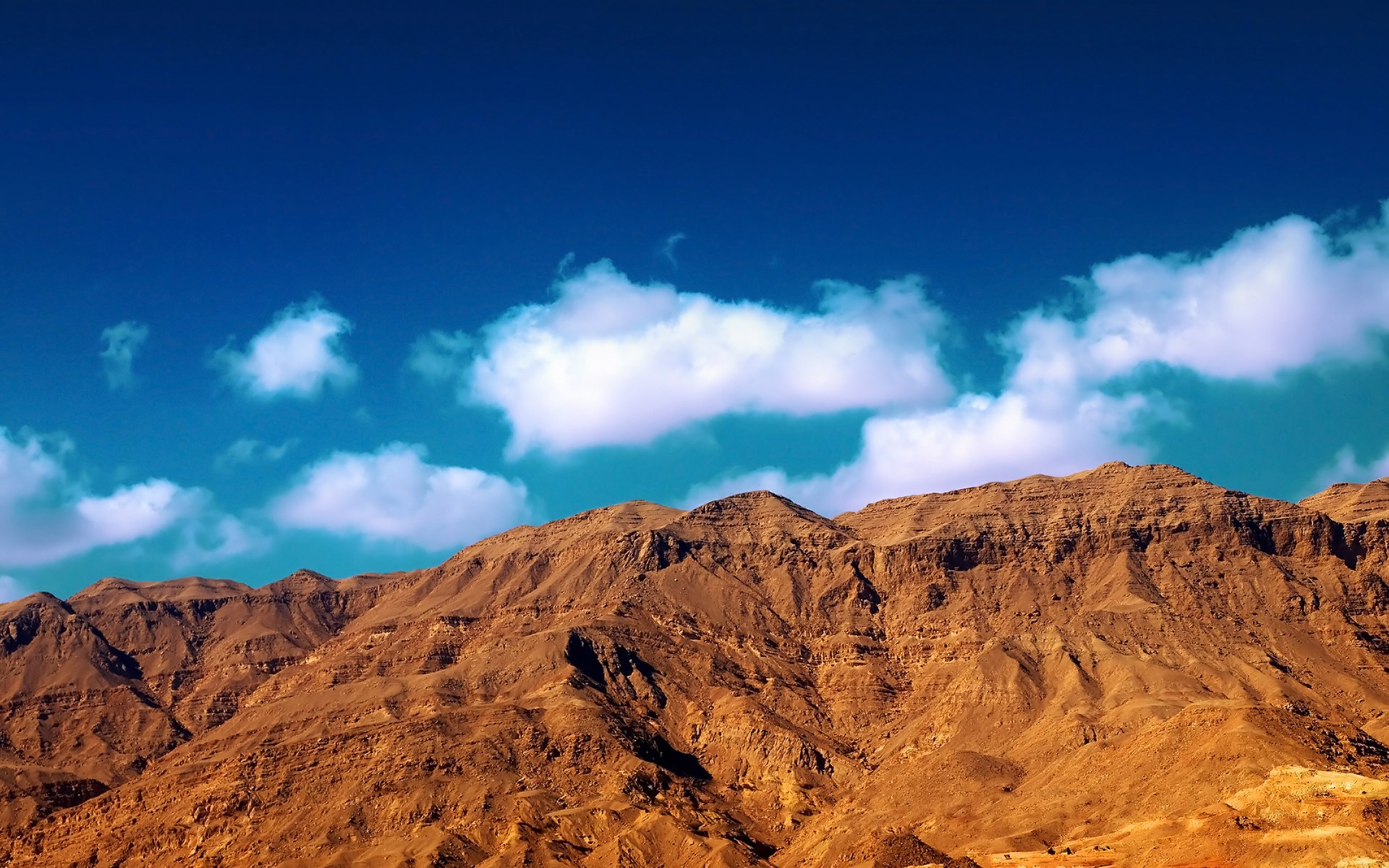 Brown mountains under a blue sky with clouds HD Wallpaper