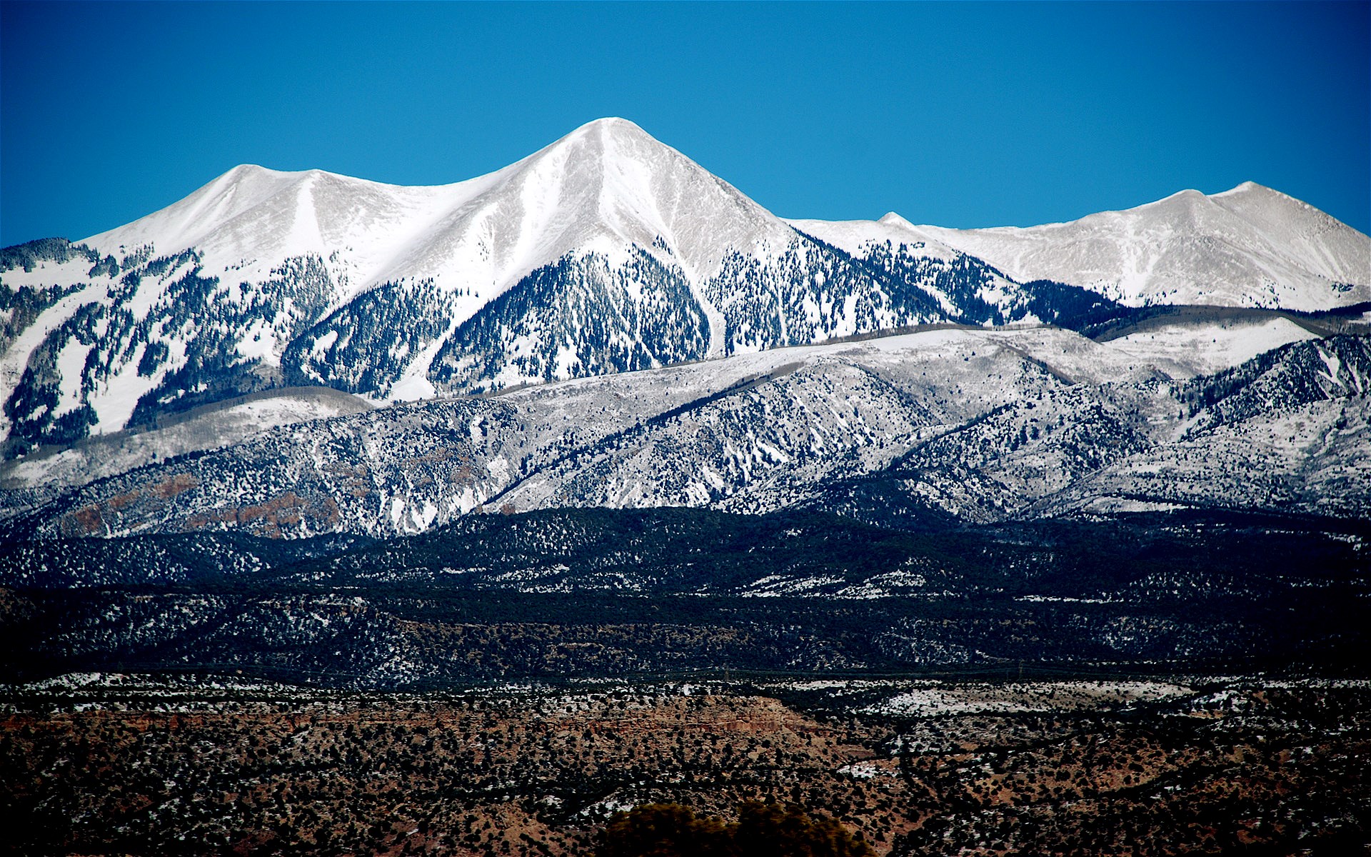 Snow-covered mountains under a clear blue sky HD Wallpaper