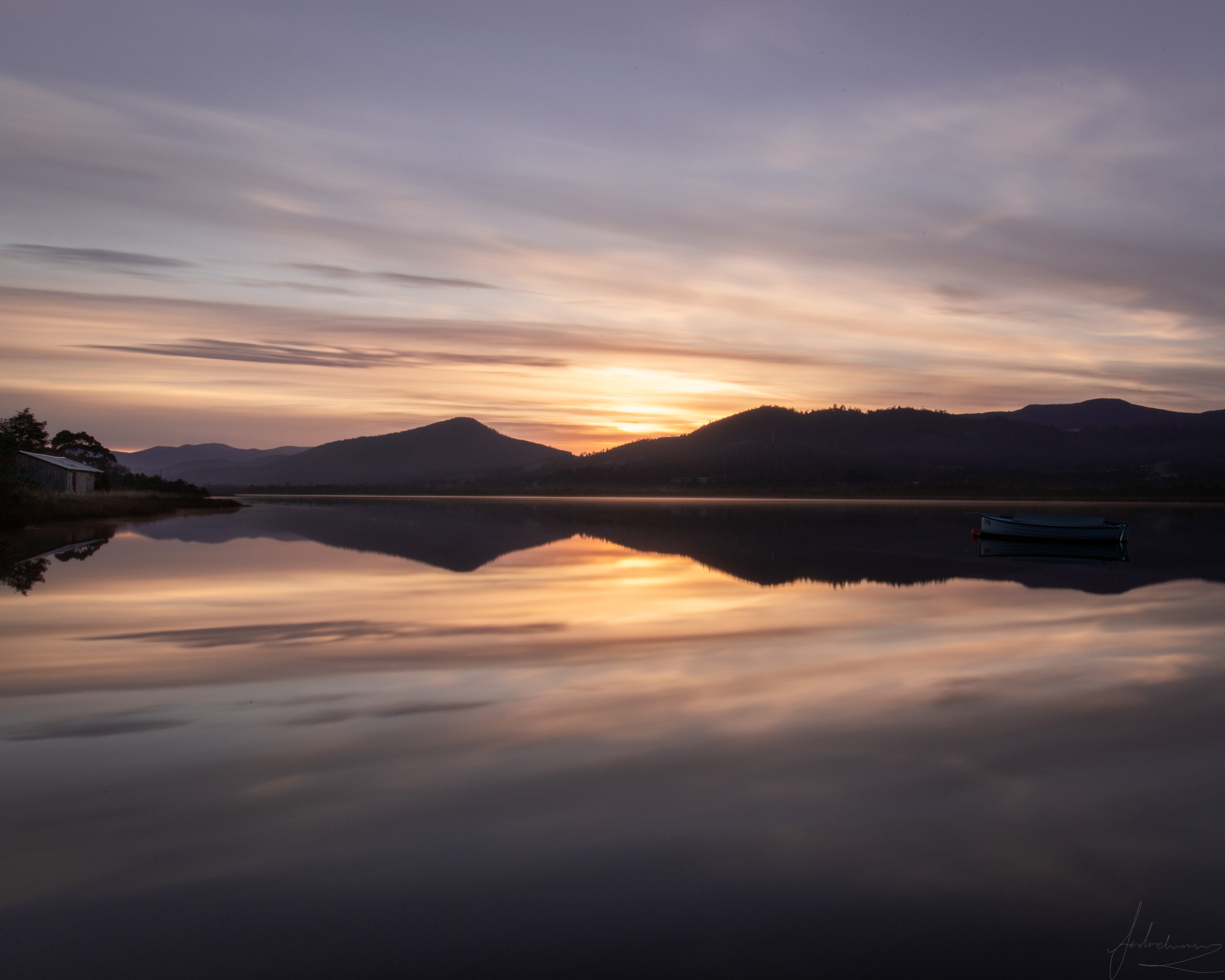 Tasmanian sunset over a lake with a boat HD Wallpaper