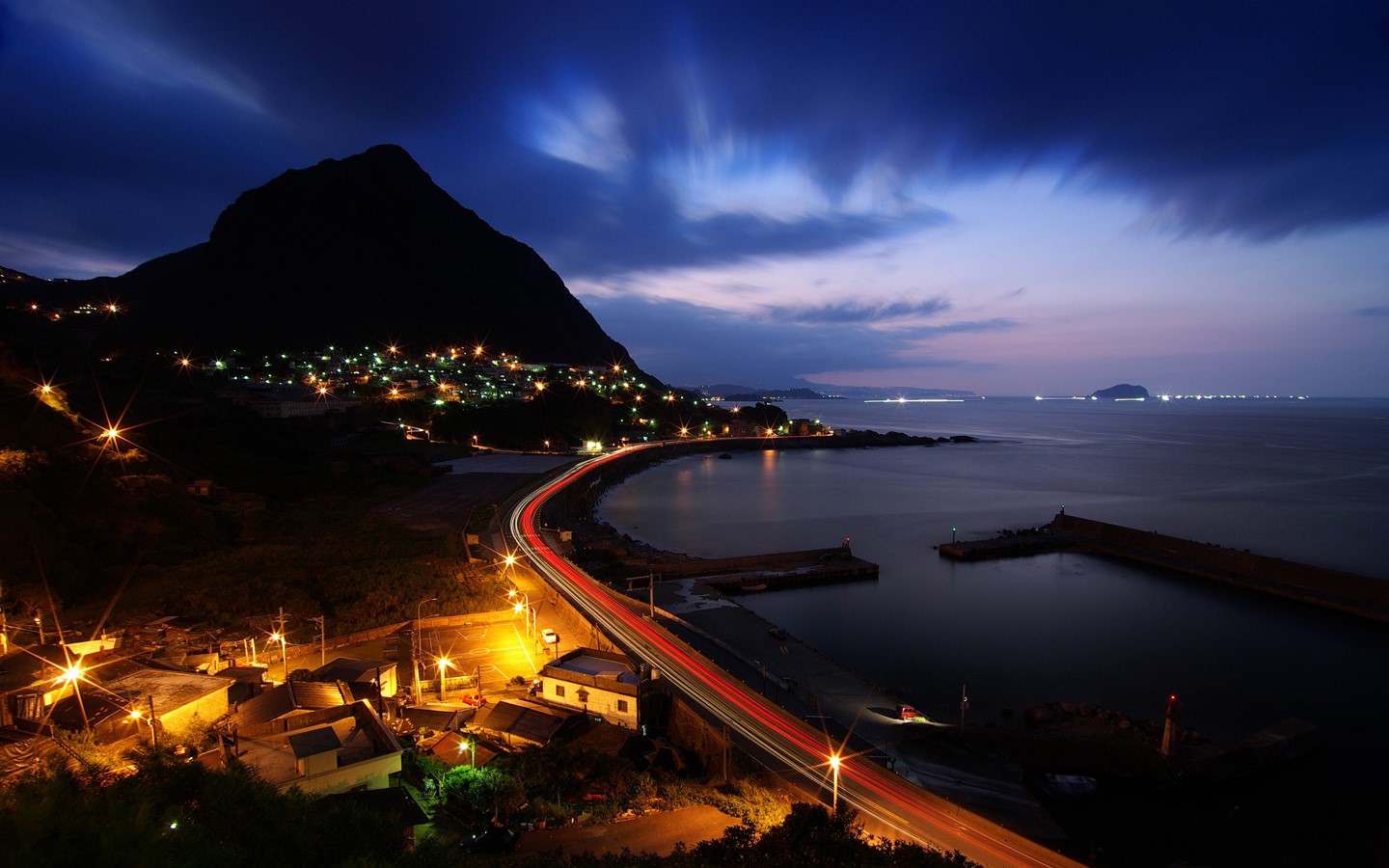 Coastal town at night with mountain and sea HD Wallpaper