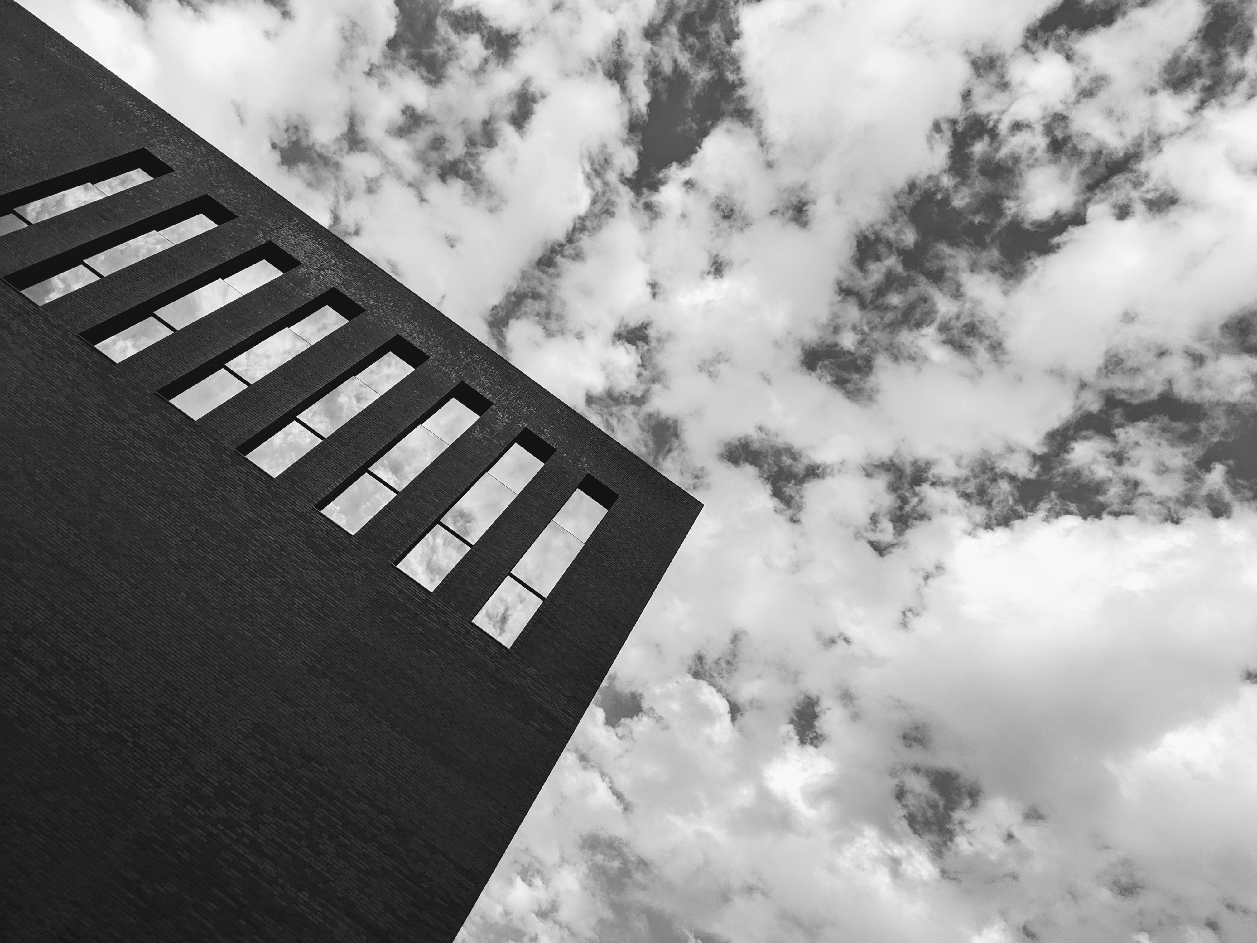 Monochrome building with windows against cloudy sky HD Wallpaper