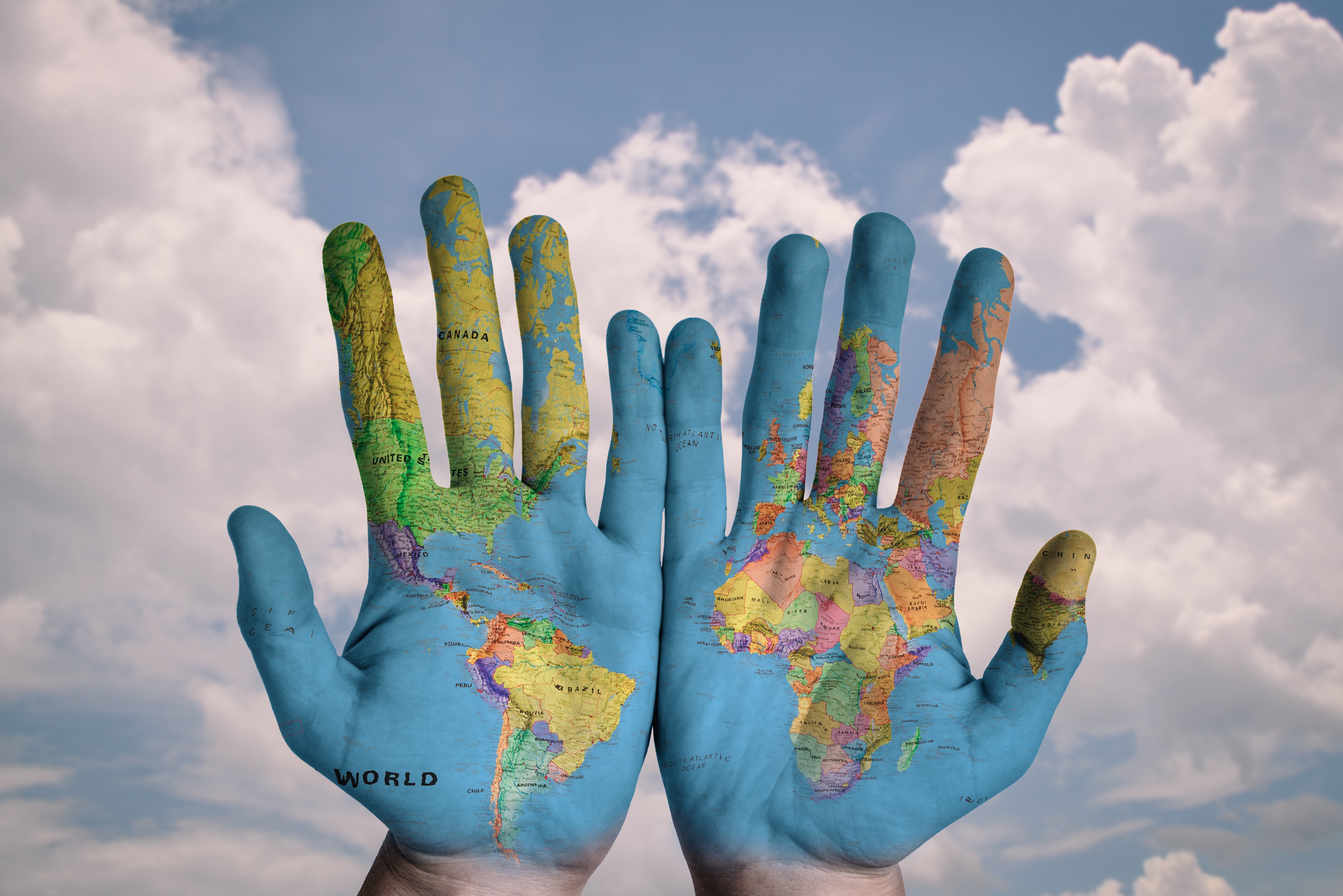 Hands with World Map against Cloudy Sky HD Wallpaper