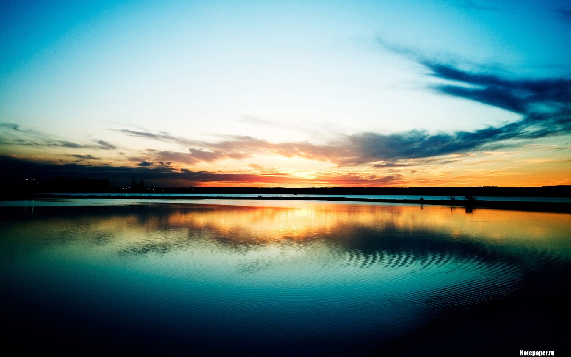 Sunset over a calm body of water with reflections HD Wallpaper