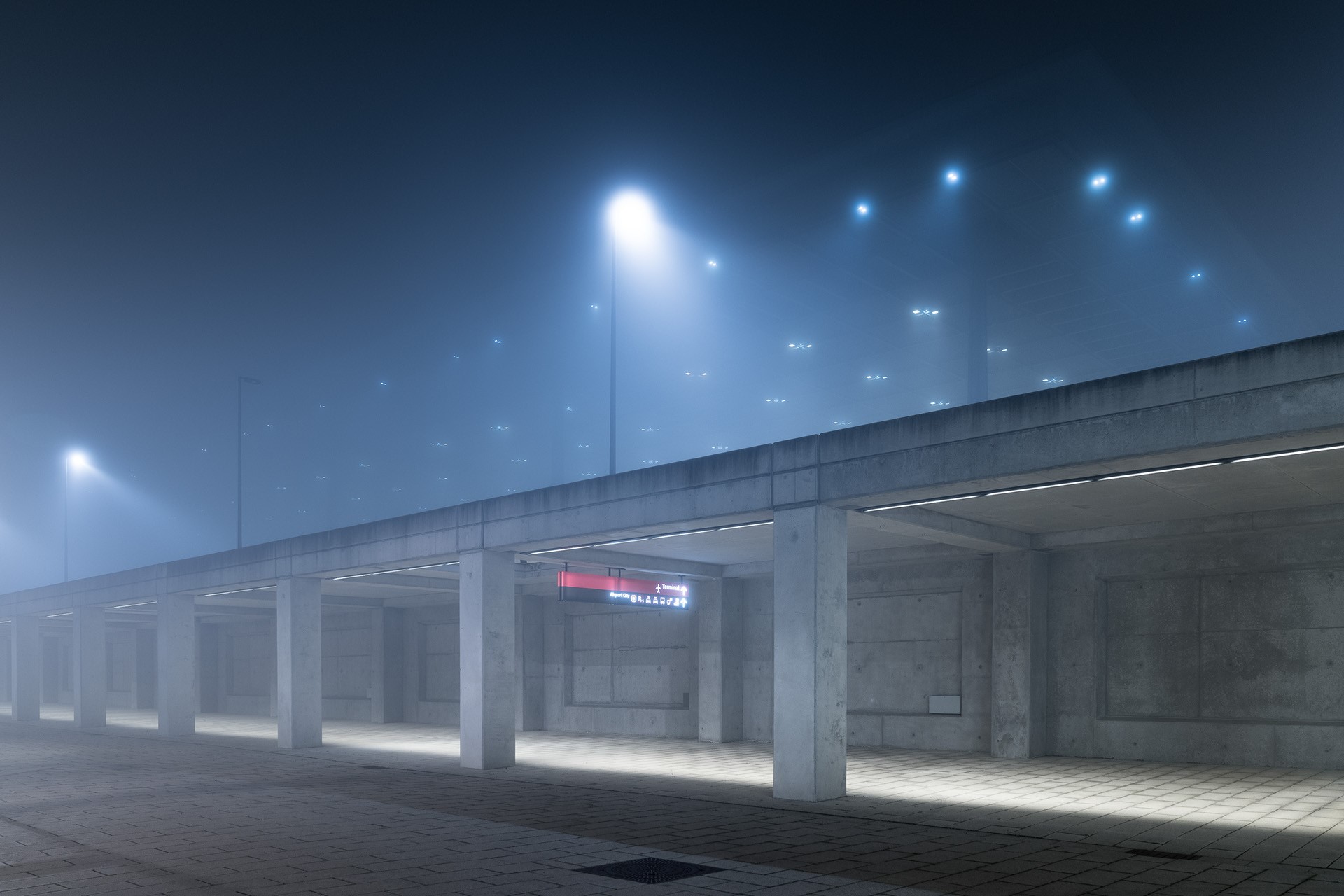 Concrete structure with streetlights at night in mist HD Wallpaper