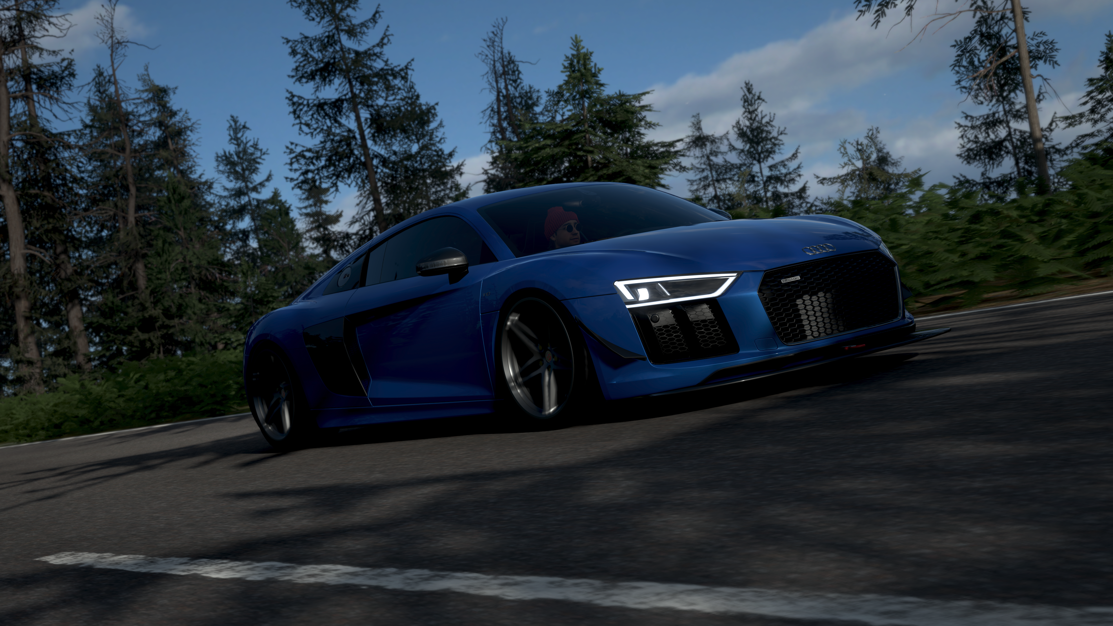 Blue Audi R8 driving on a road in a forest HD Wallpaper