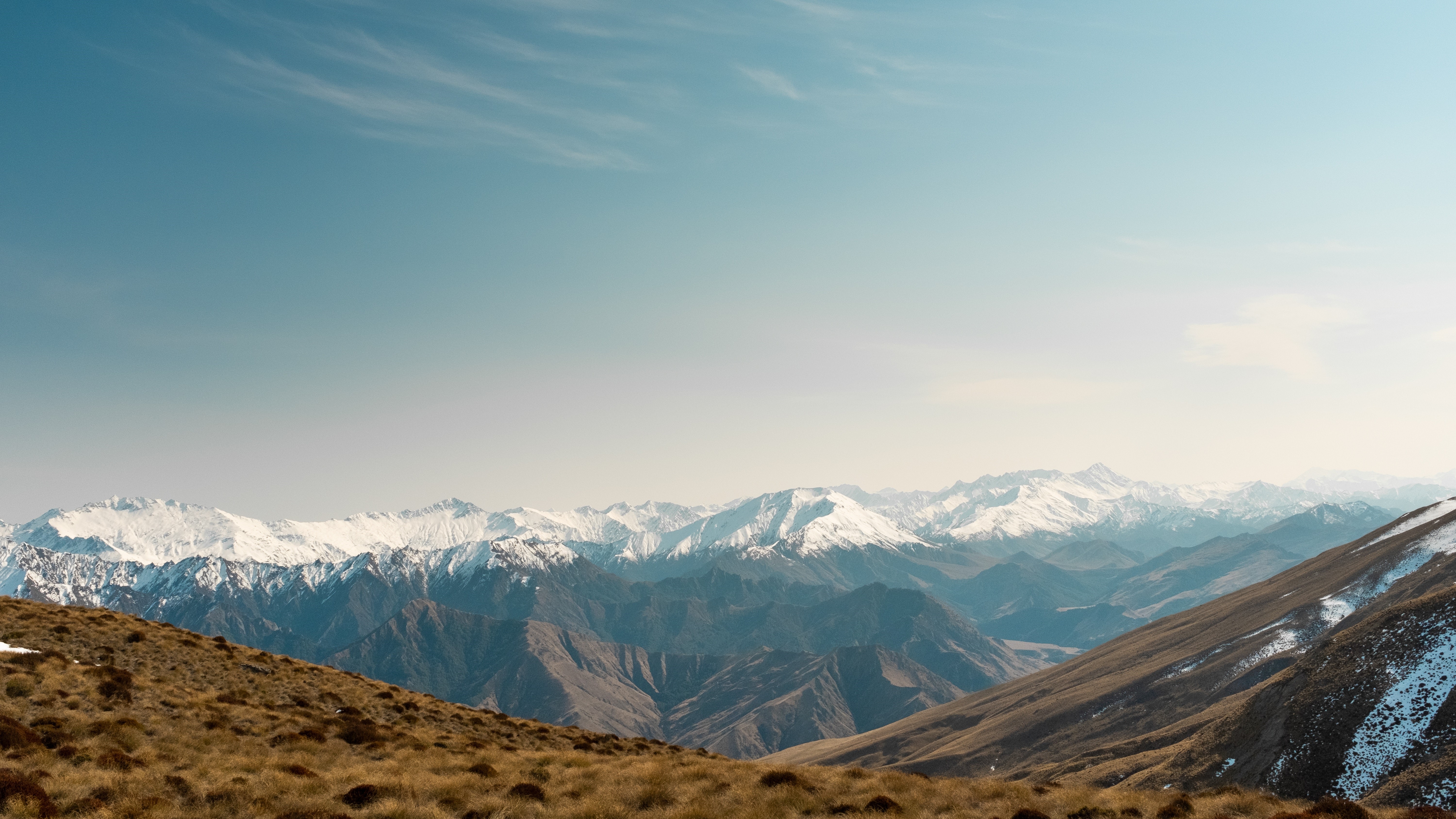 4K snow-capped mountains with dry grass foreground HD Wallpaper