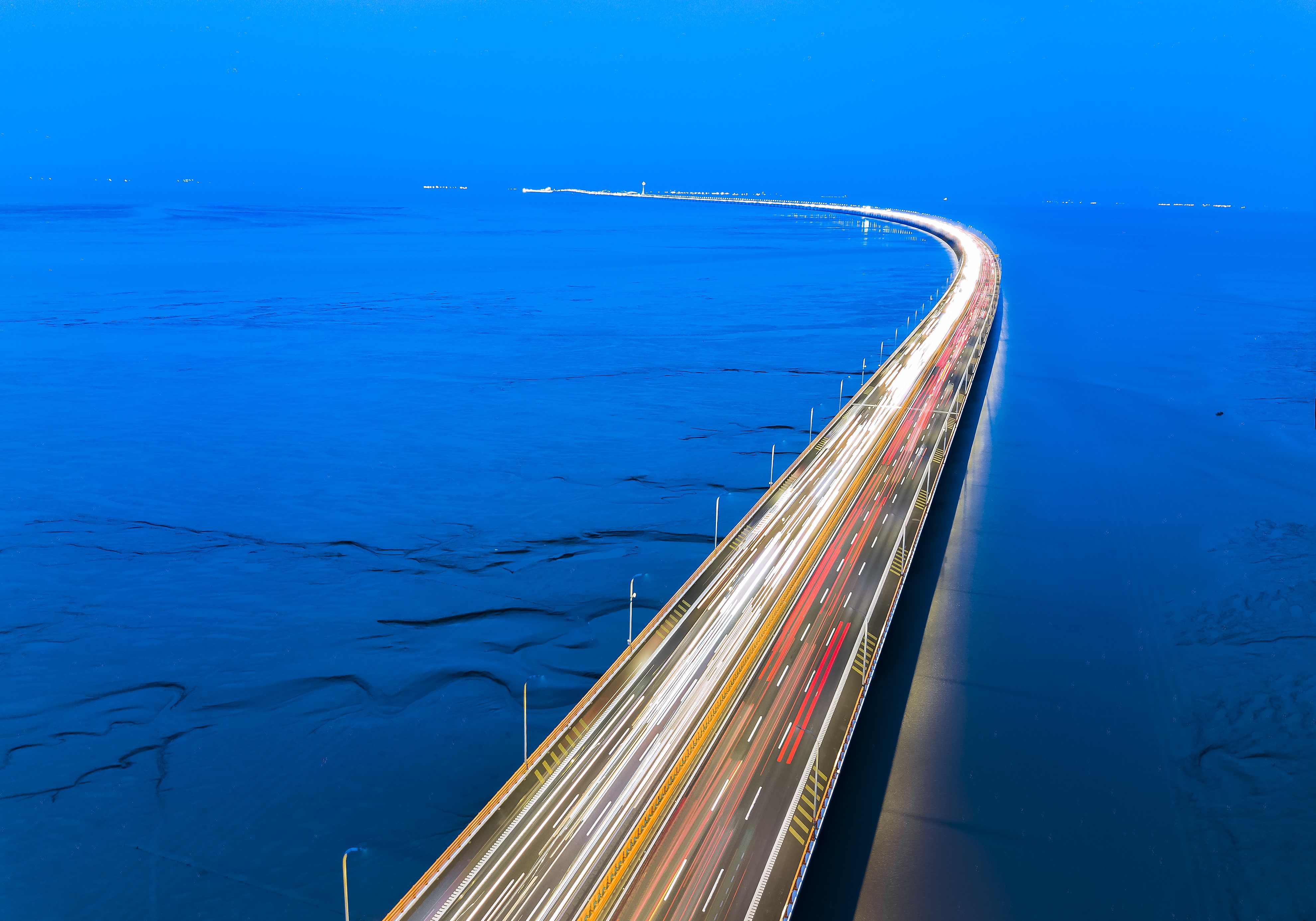 4K bridge over blue water with light trails HD Wallpaper