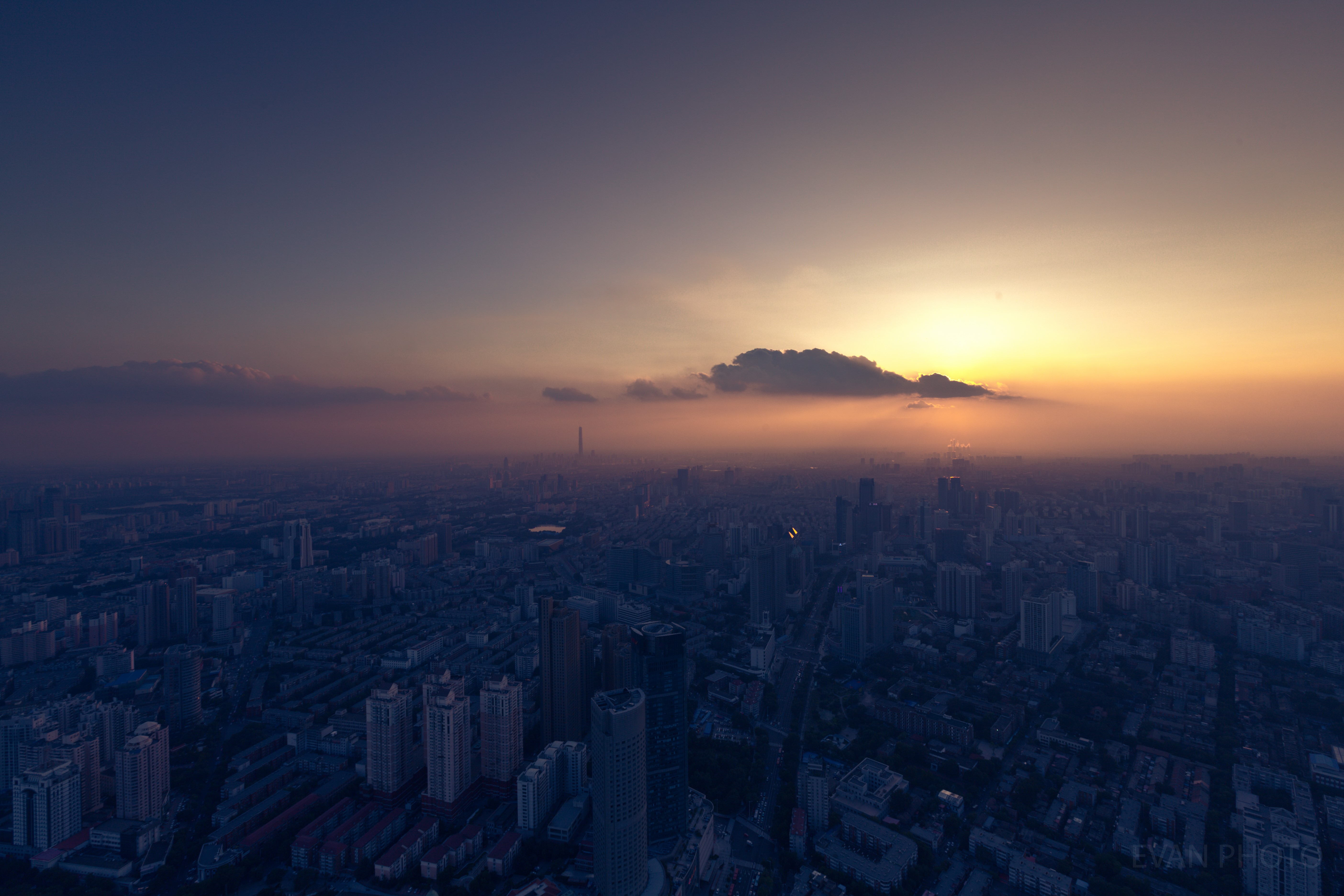 Cityscape at sunset with hazy sky HD Wallpaper
