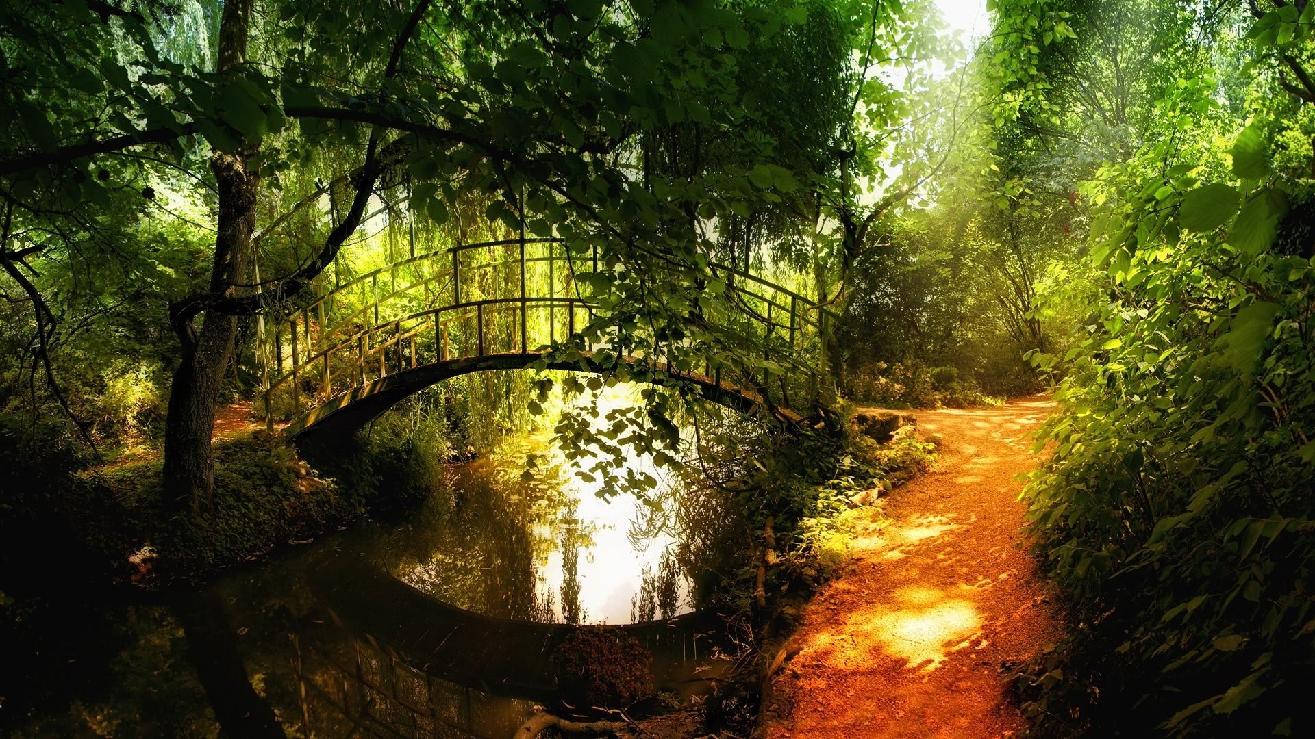 A scenic park with a bridge over a stream HD Wallpaper