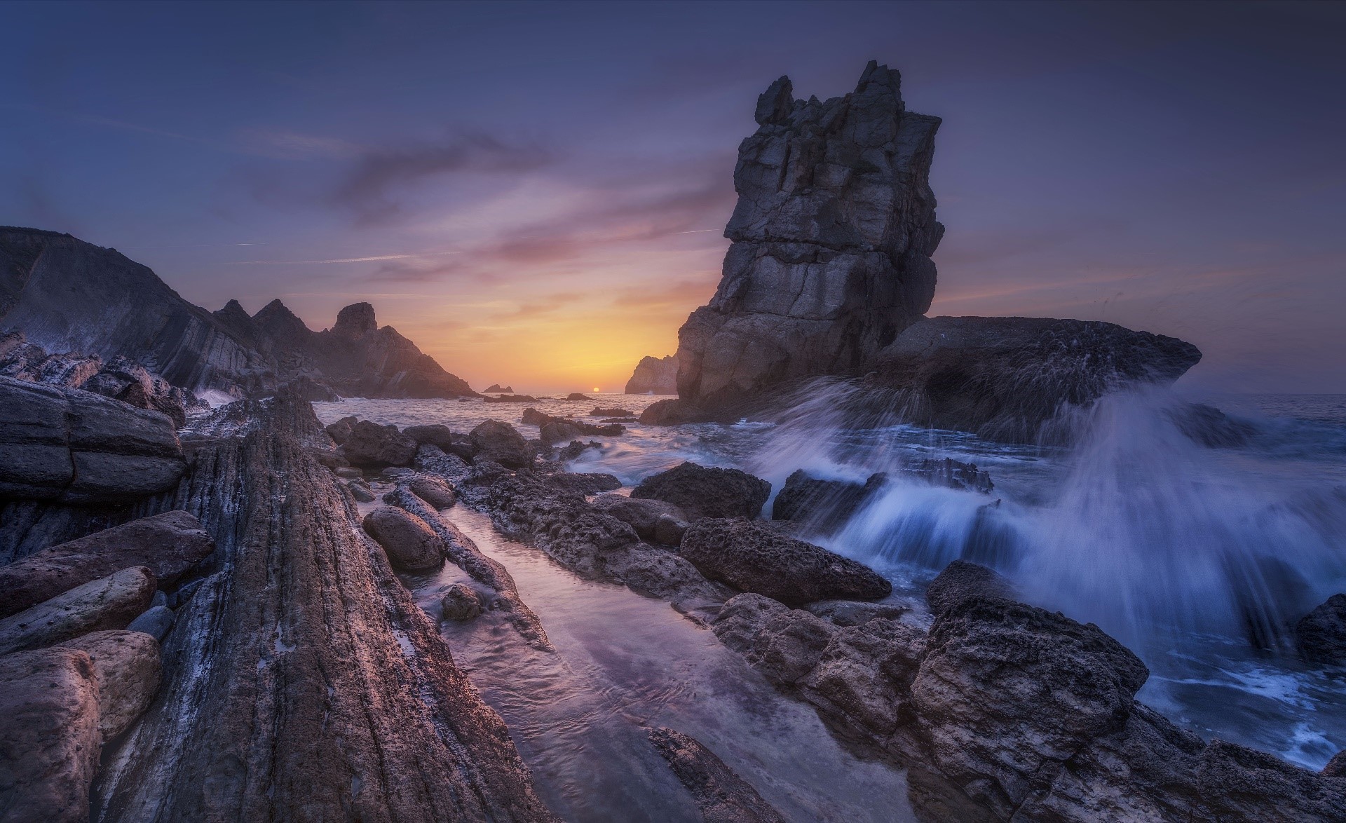 Rocky coast with waves crashing at sunset HD Wallpaper