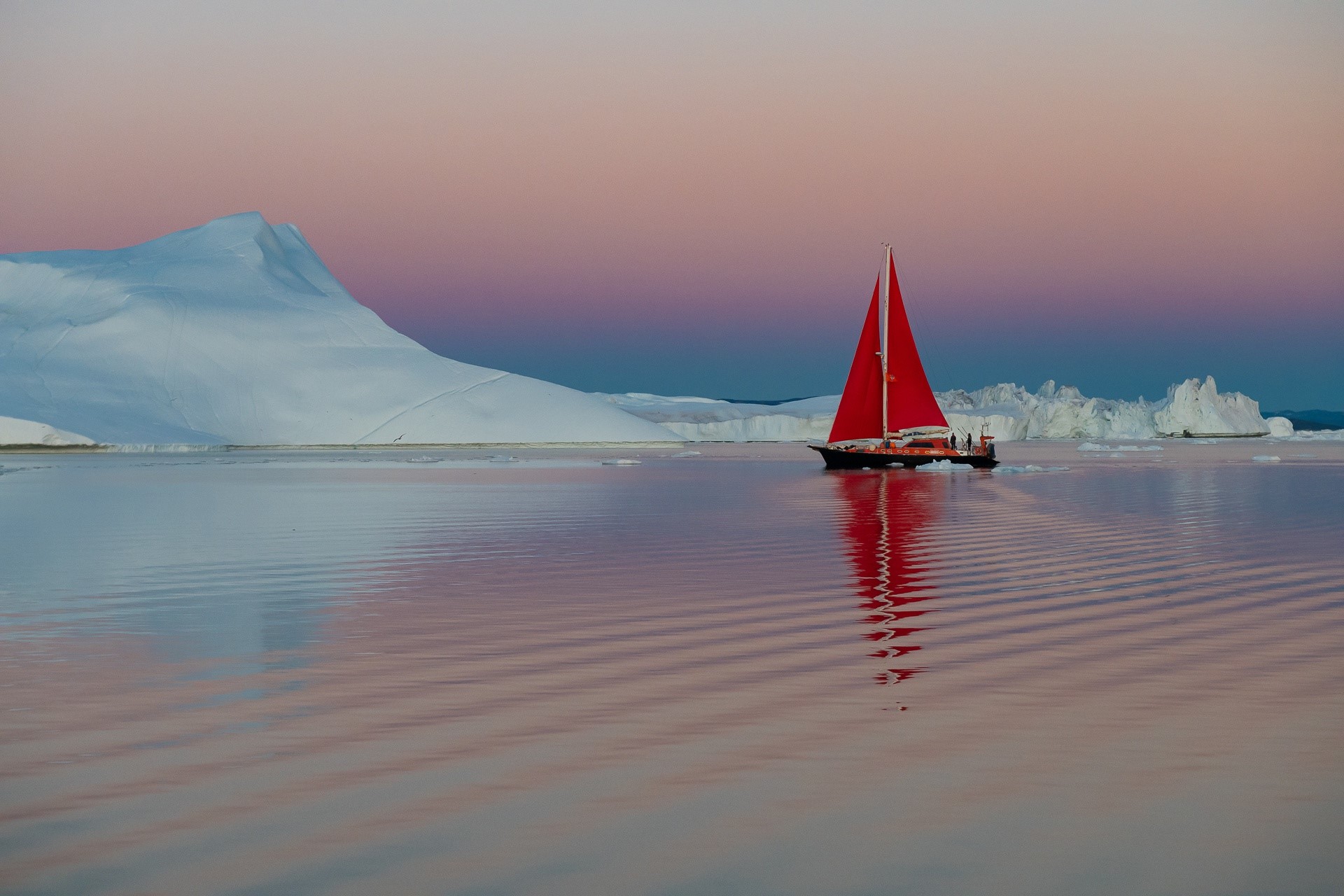 Sailboat with red sail on water near icebergs HD Wallpaper