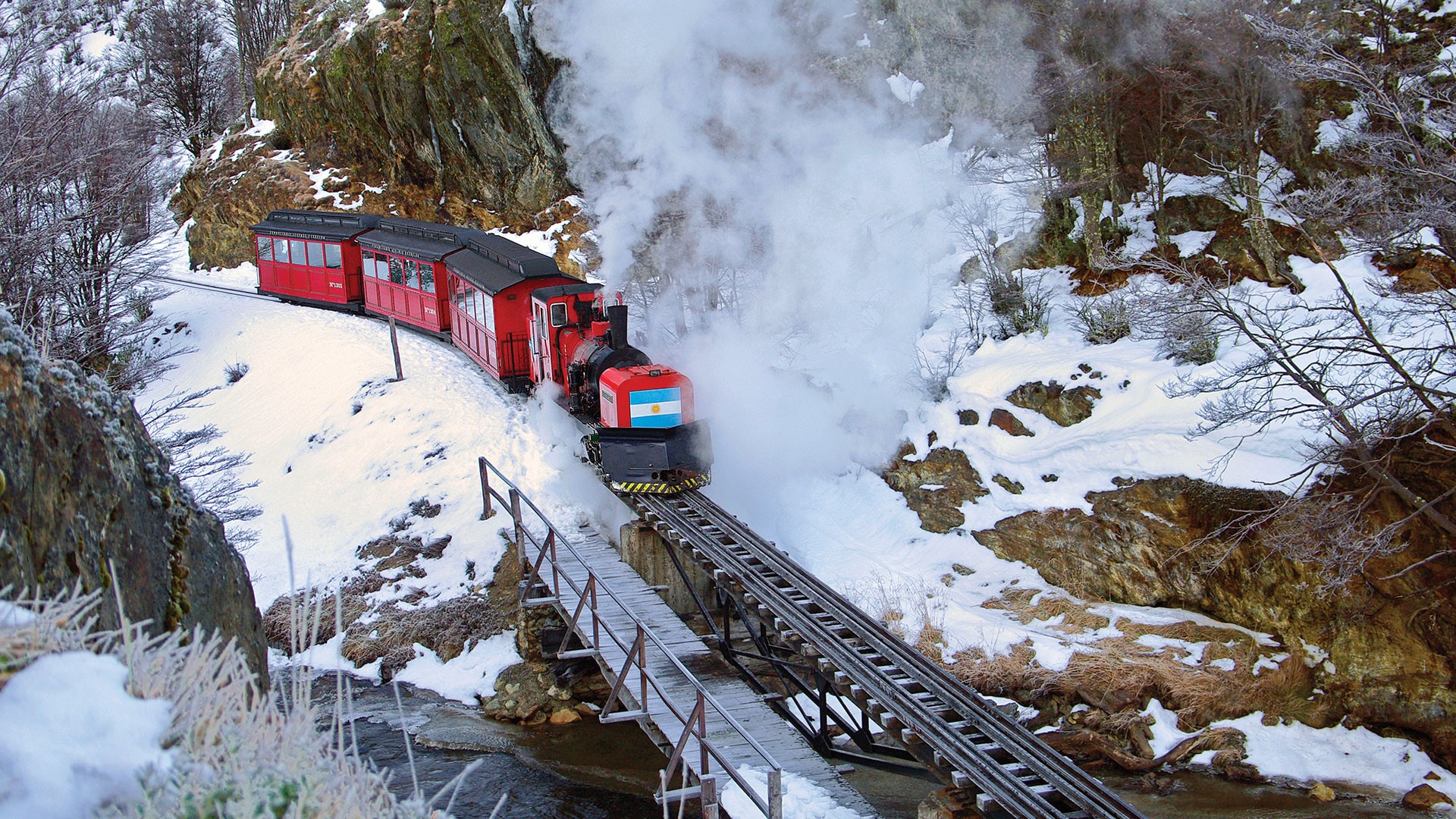 Steam train with Argentine flag in snowy Patagonia HD Wallpaper
