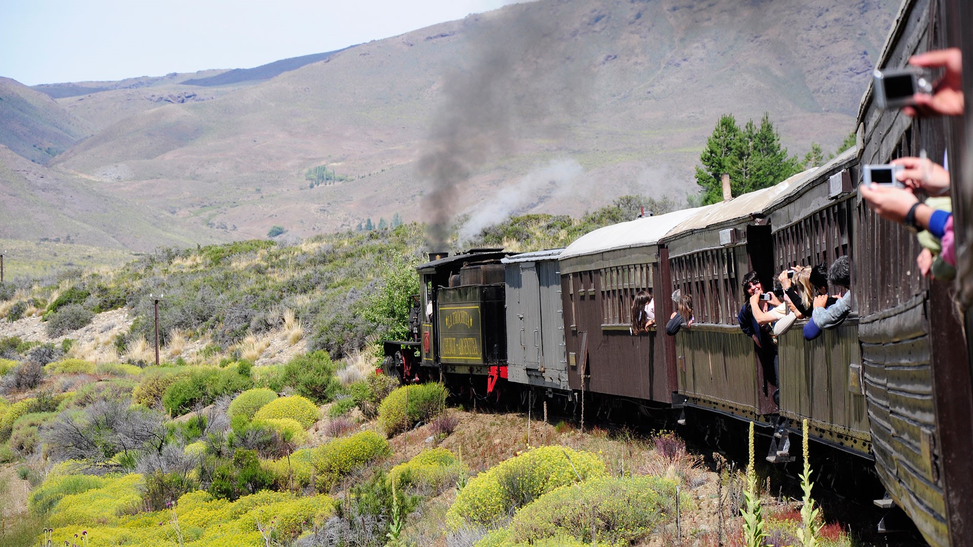 Steam train traveling through a Patagonian landscape HD Wallpaper