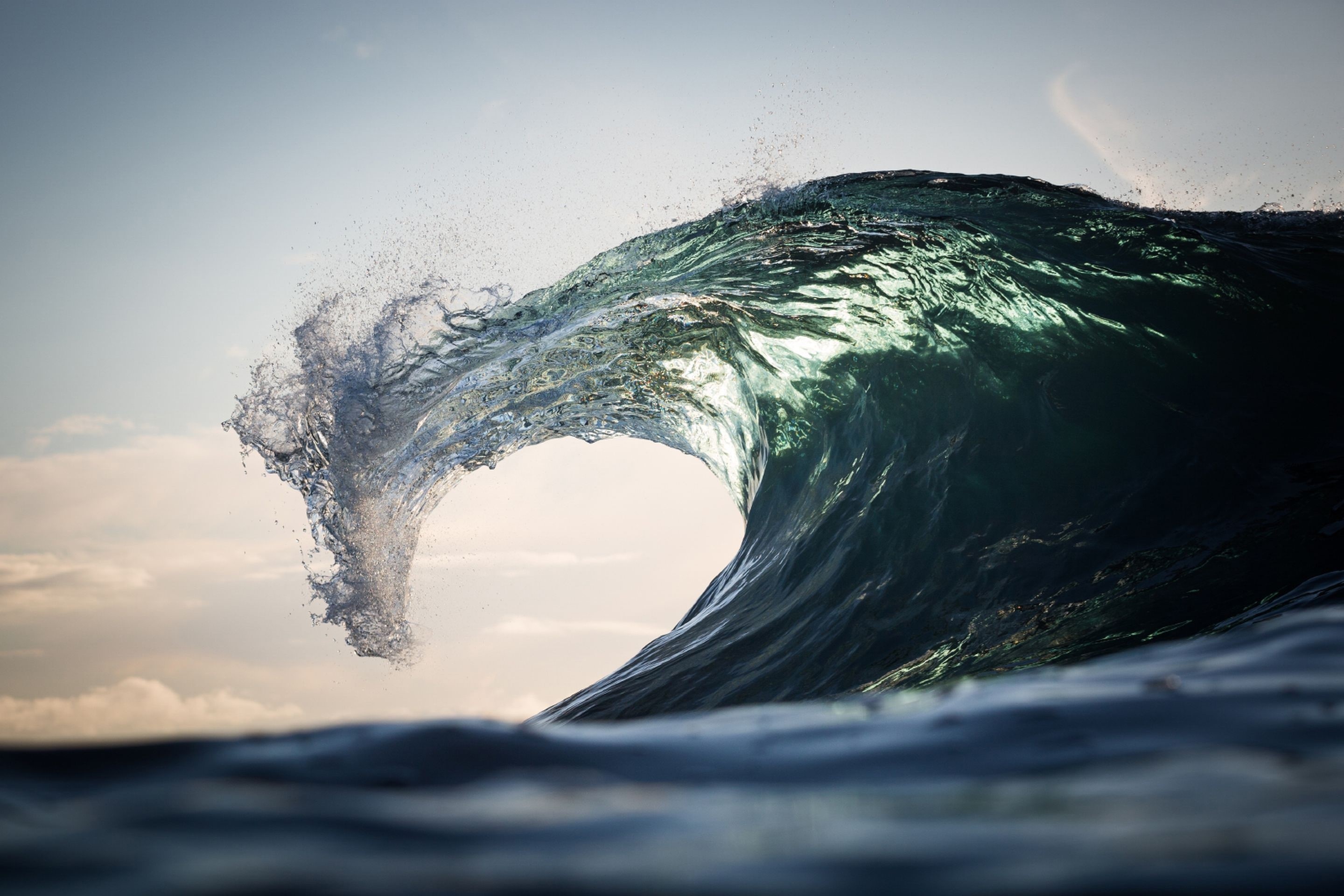 A large wave crests and breaks in the ocean HD Wallpaper