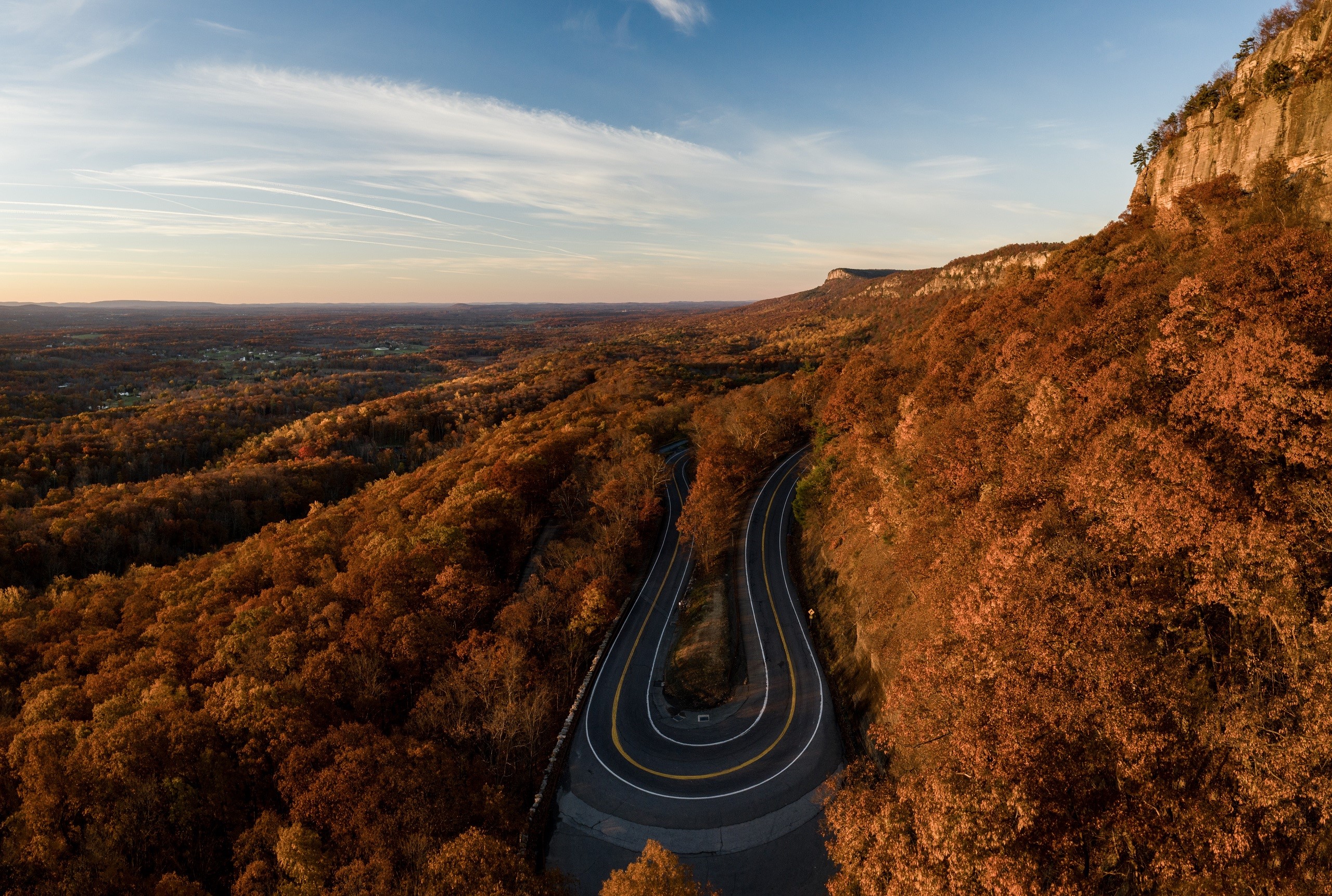 Winding mountain road through autumn forest HD Wallpaper