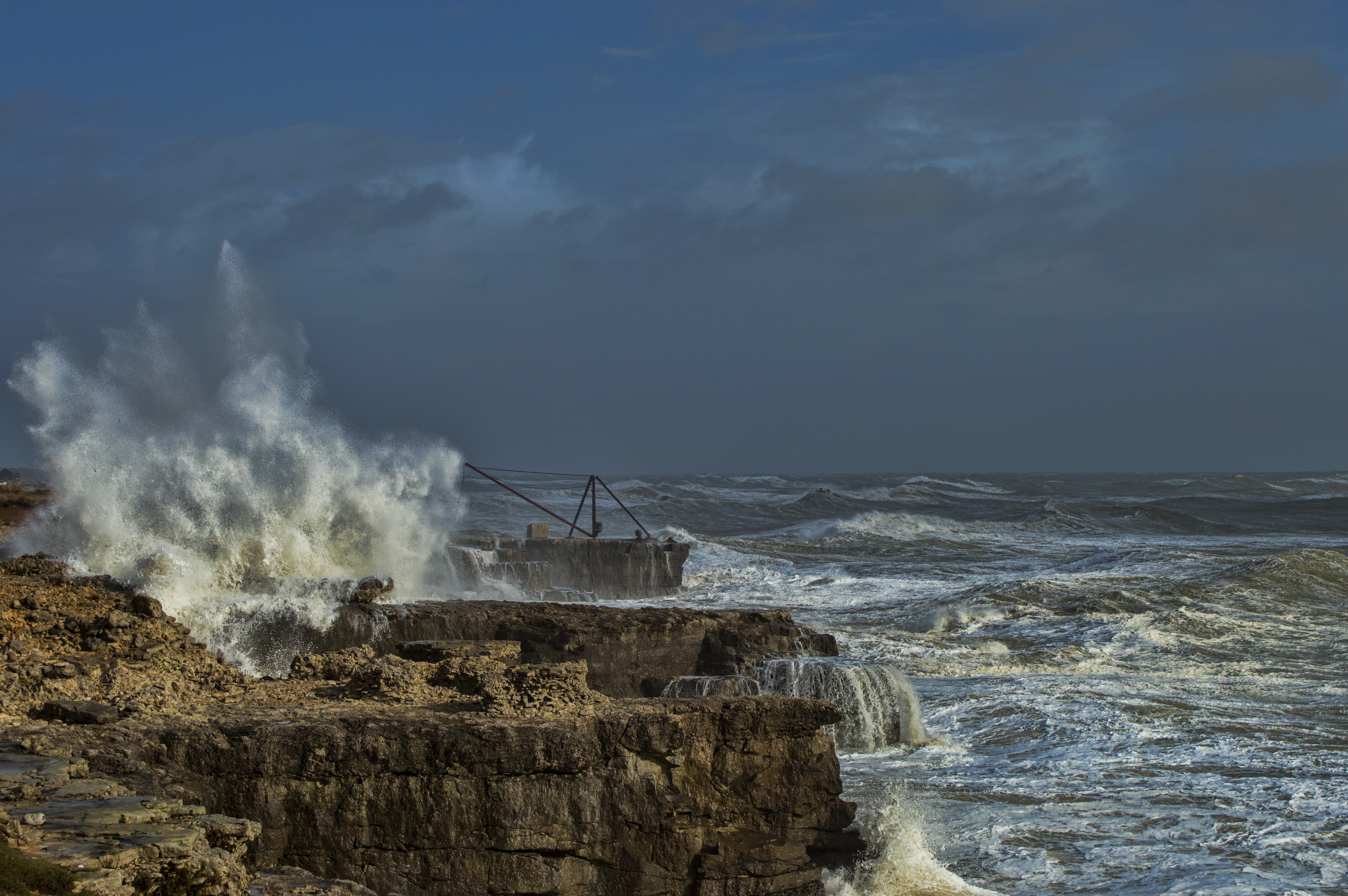 Stormy coast with waves crashing on rocks HD Wallpaper