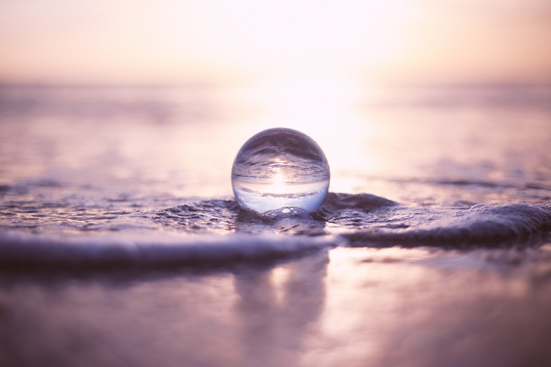 Glass sphere on a beach at sunset HD Wallpaper